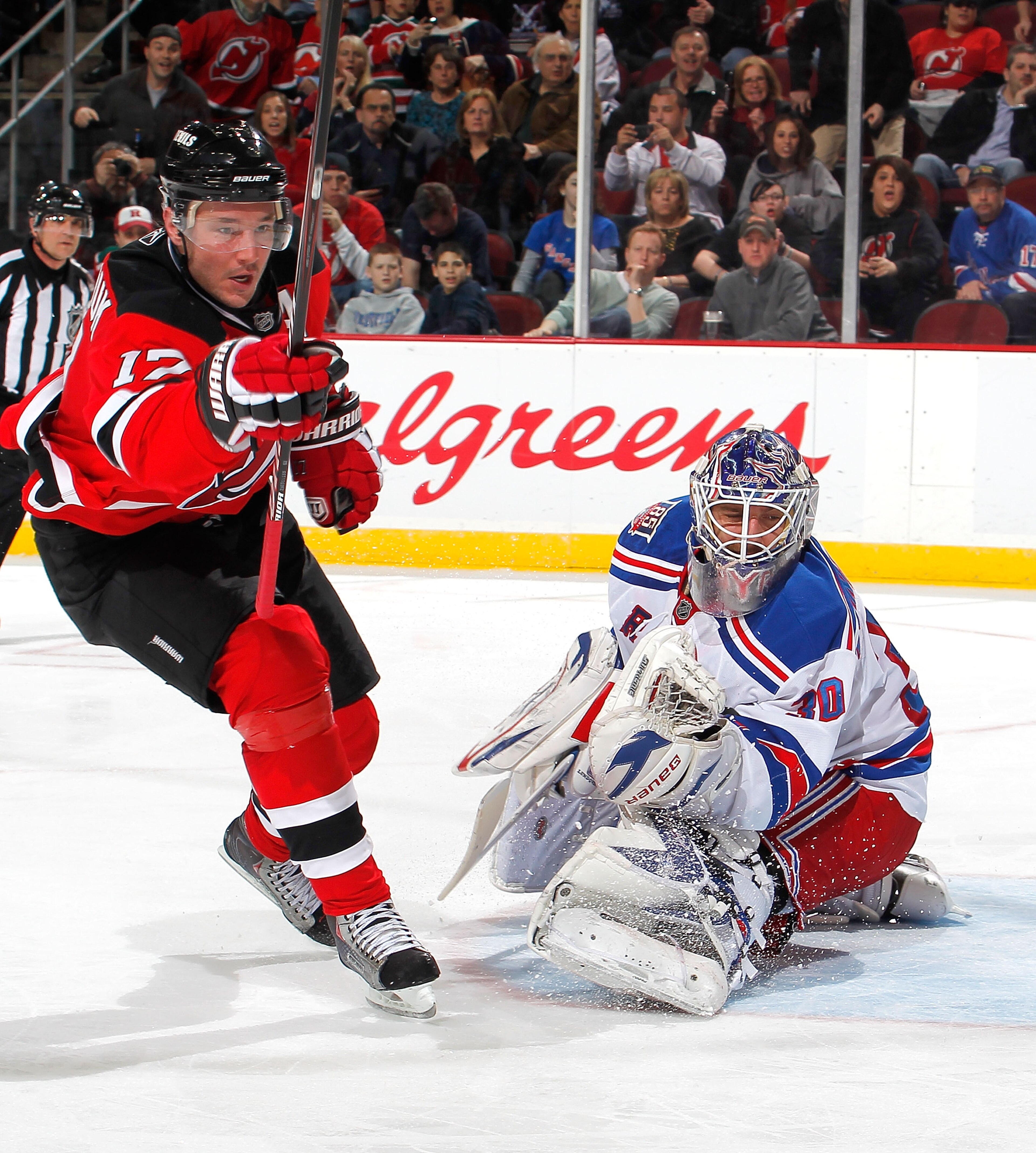 NEWARK, NJ - FEBRUARY 18:  Ilya Kovalchuk #17 of the New Jersey Devils begins to celebrate his goal as goalie Henrik Lundqvist #30 of the New York Rangers looks back towards the goal in the second period of an NHL hockey game at the Prudential Center on F