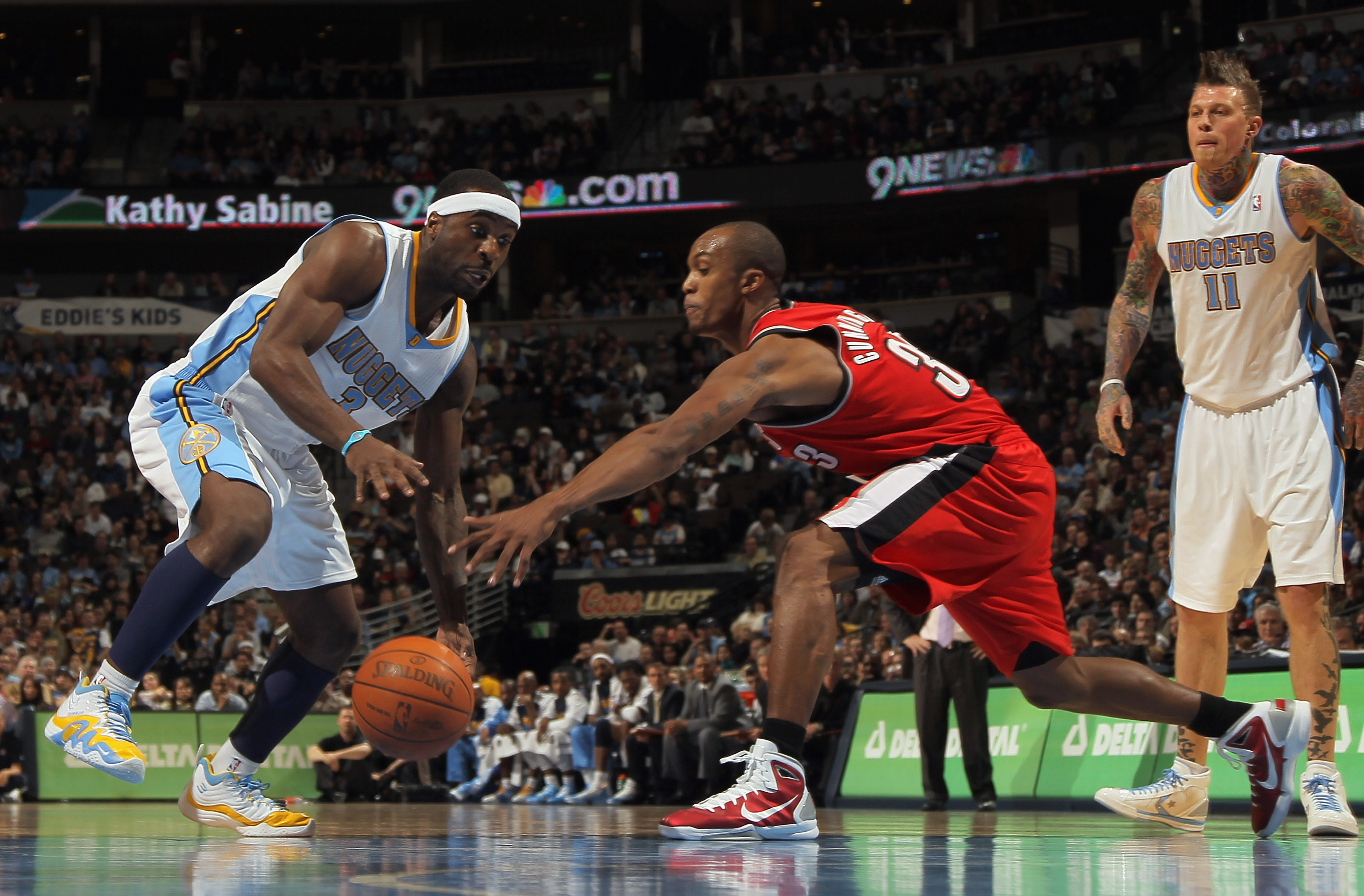 DENVER - DECEMBER 28:  Ty Lawson #3 of the Denver Nuggets dribbles the ball against Dante Cunningham #33 of the Portland Trail Blazers at Pepsi Center on December 28, 2010 in Denver, Colorado. The Nuggets defeated the Blazers 95-77. NOTE TO USER: User exp