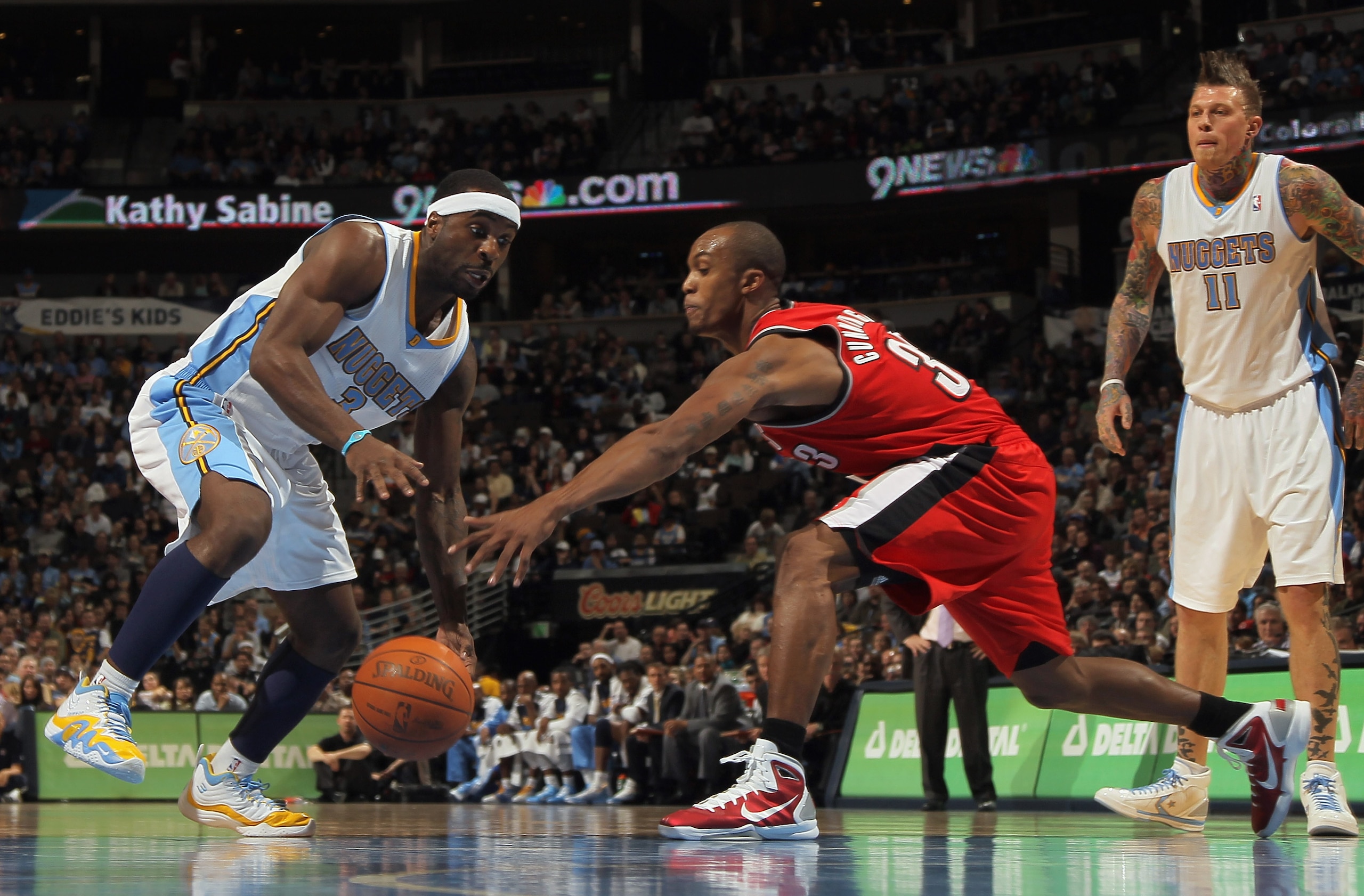 DENVER - DECEMBER 28:  Ty Lawson #3 of the Denver Nuggets dribbles the ball against Dante Cunningham #33 of the Portland Trail Blazers at Pepsi Center on December 28, 2010 in Denver, Colorado. The Nuggets defeated the Blazers 95-77. NOTE TO USER: User exp