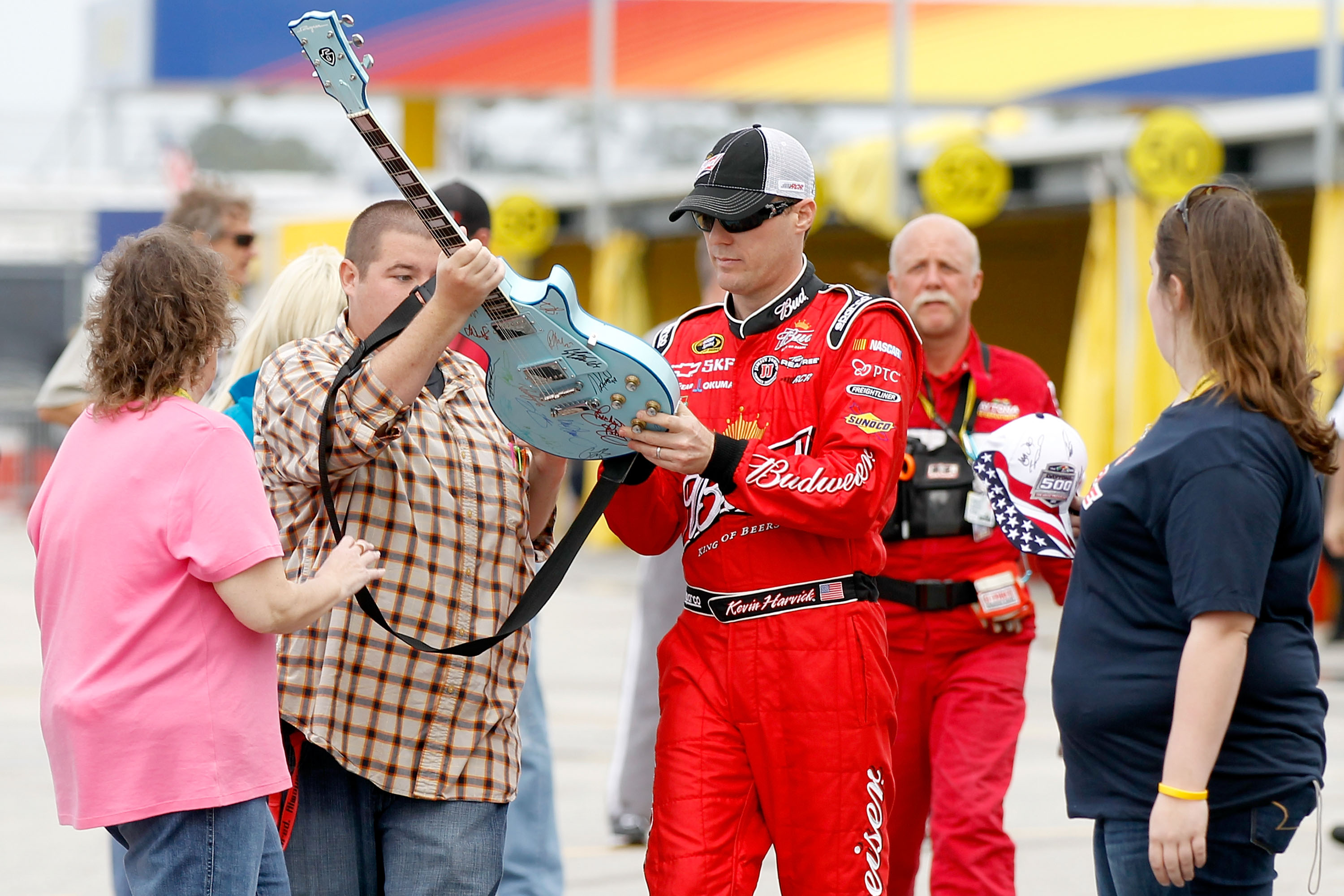 DAYTONA BEACH, FL - FEBRUARY 16:  Kevin Harvick, driver of the #29 Budweiser Chevrolet, signs a guitar in the garage area during practice for the NASCAR Sprint Cup Series Daytona 500 at Daytona International Speedway on February 16, 2011 in Daytona Beach,