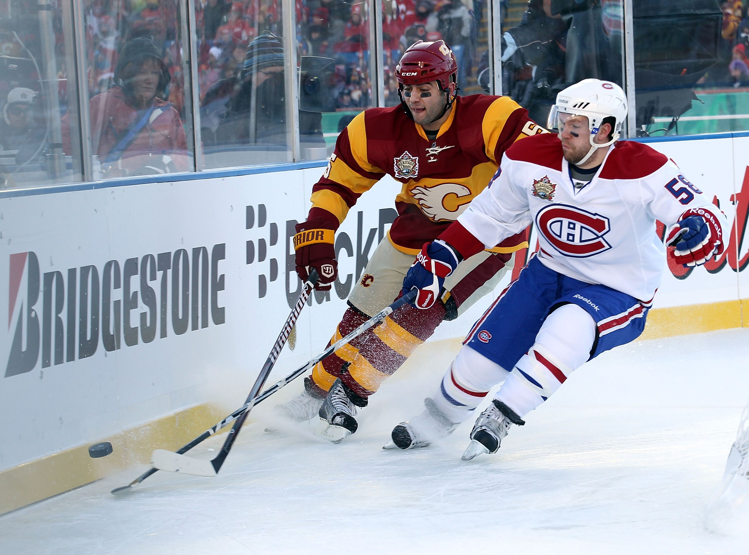 CALGARY, AB - FEBRUARY 20: Mark Giordano #5 of the Calgary Flames and David Desharnais #58 of the Montreal Canadiens battle for the puck during the 2011 NHL Heritage Classic Game at McMahon Stadium on February 20, 2011 in Calgary, Alberta, Canada.  (Photo
