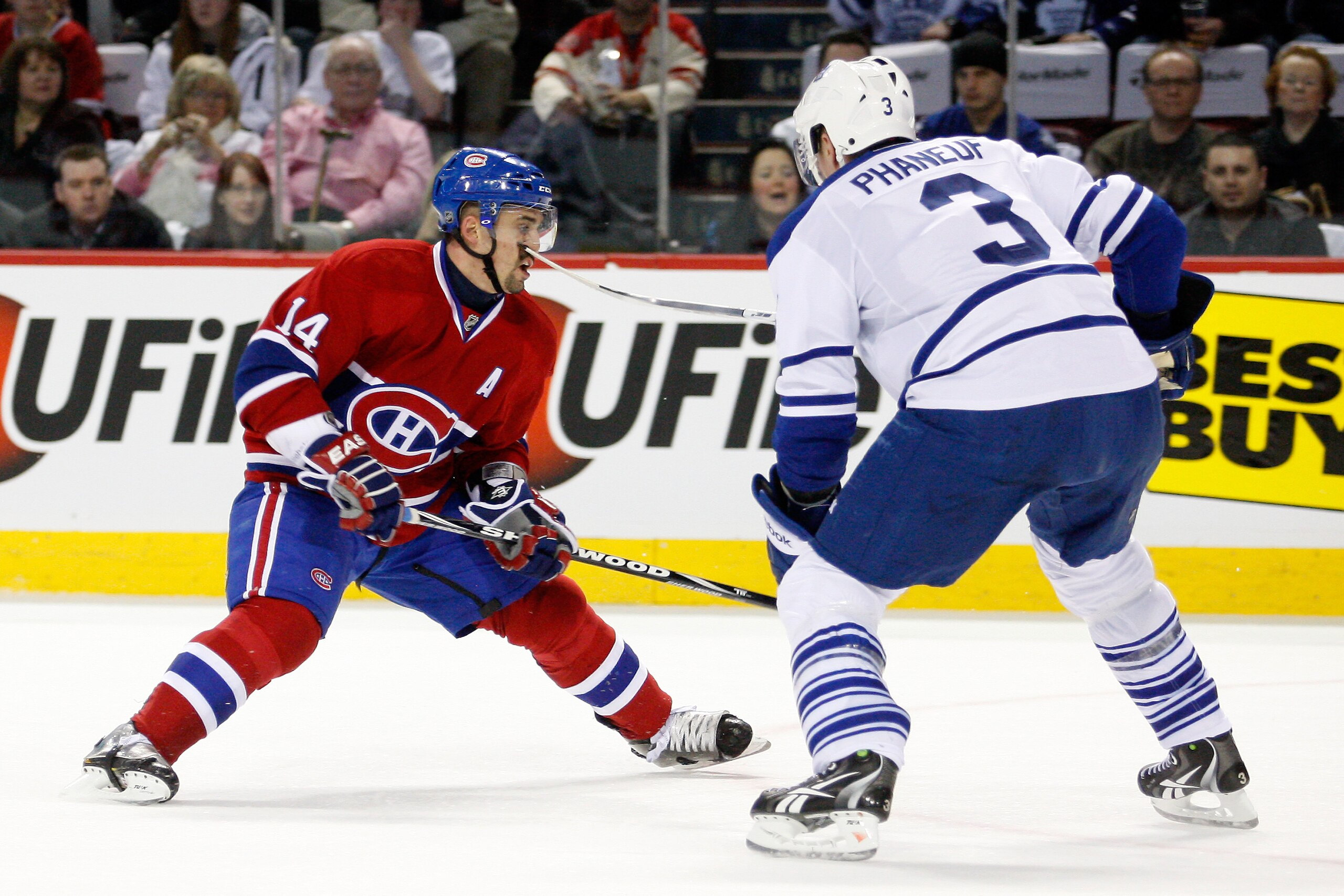 MONTREAL, CANADA - FEBRUARY 12:  Dion Phaneuf #3 of the Toronto Maple Leafs high sticks Tomas Plekanec #14 of the Montreal Canadiens during the NHL game at the Bell Centre on February 12, 2011 in Montreal, Quebec, Canada.  (Photo by Richard Wolowicz/Getty