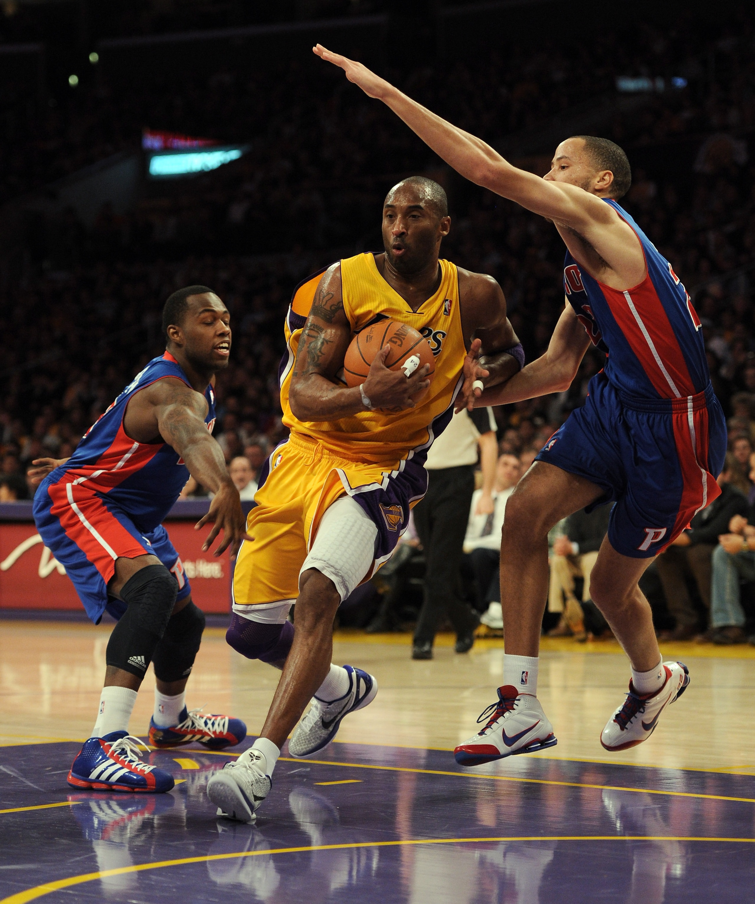 LOS ANGELES, CA - JANUARY 04:  Kobe Bryant #24 of the Los Angeles Lakers steps between Tayshaun Prince #22 and Rodney Stuckey #3 of the Detroit Pistons at the Staples Center on January 4, 2011 in Los Angeles, California. NOTE TO USER: User expressly ackno