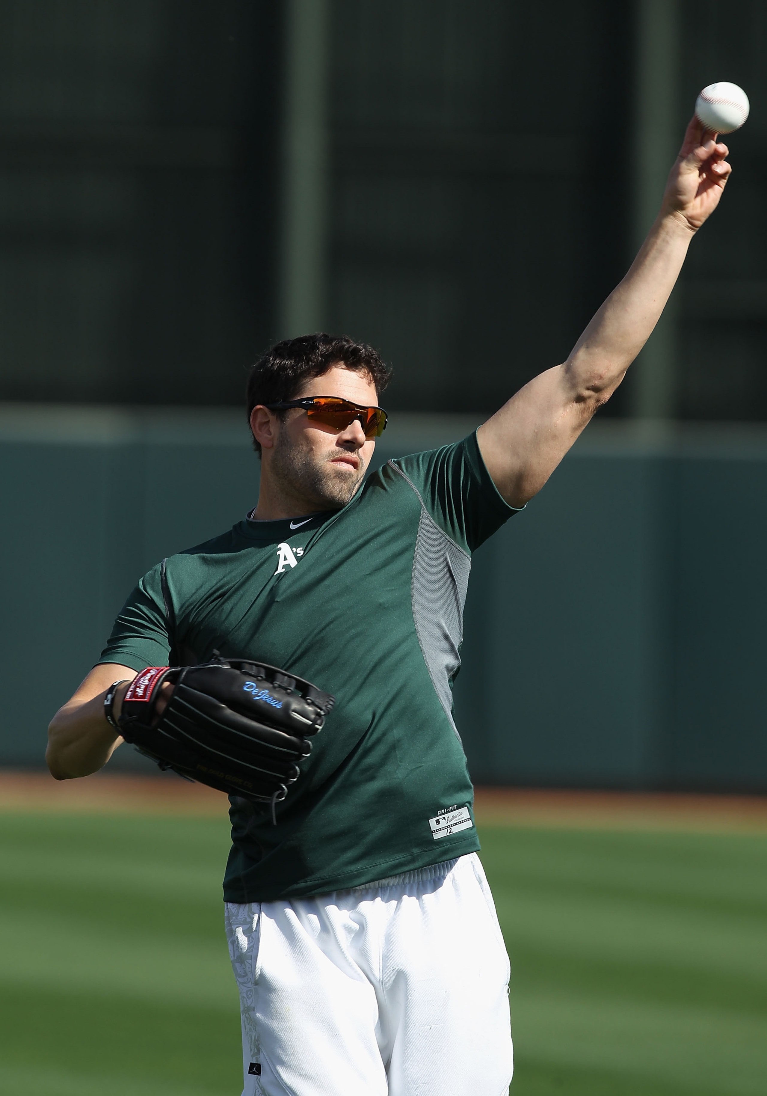 PHOENIX, AZ - FEBRUARY 16:  David DeJesus #12 of the Oakland Athletics warms up during a MLB spring training practice at Phoenix Municipal Stadium on February 16, 2011 in Phoenix, Arizona.  (Photo by Christian Petersen/Getty Images)