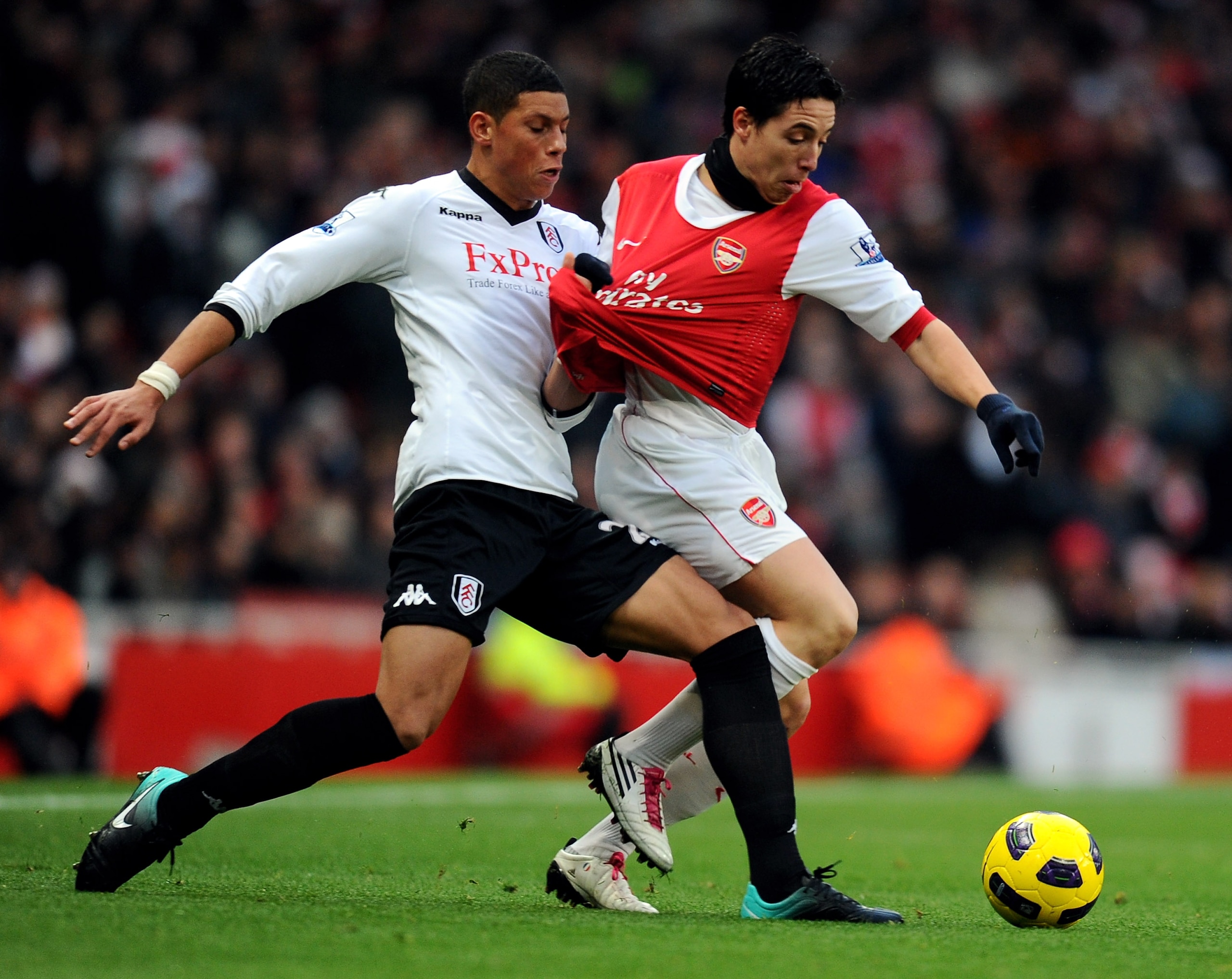 LONDON, ENGLAND - DECEMBER 04:  Samir Nasri of Arsenal (R) is tackled by Matthew Briggs of Fulham during the Barclays Premier League match between Arsenal and Fulham at the Emirates Stadium on December 4, 2010 in London, England.  (Photo by Mike Hewitt/Ge