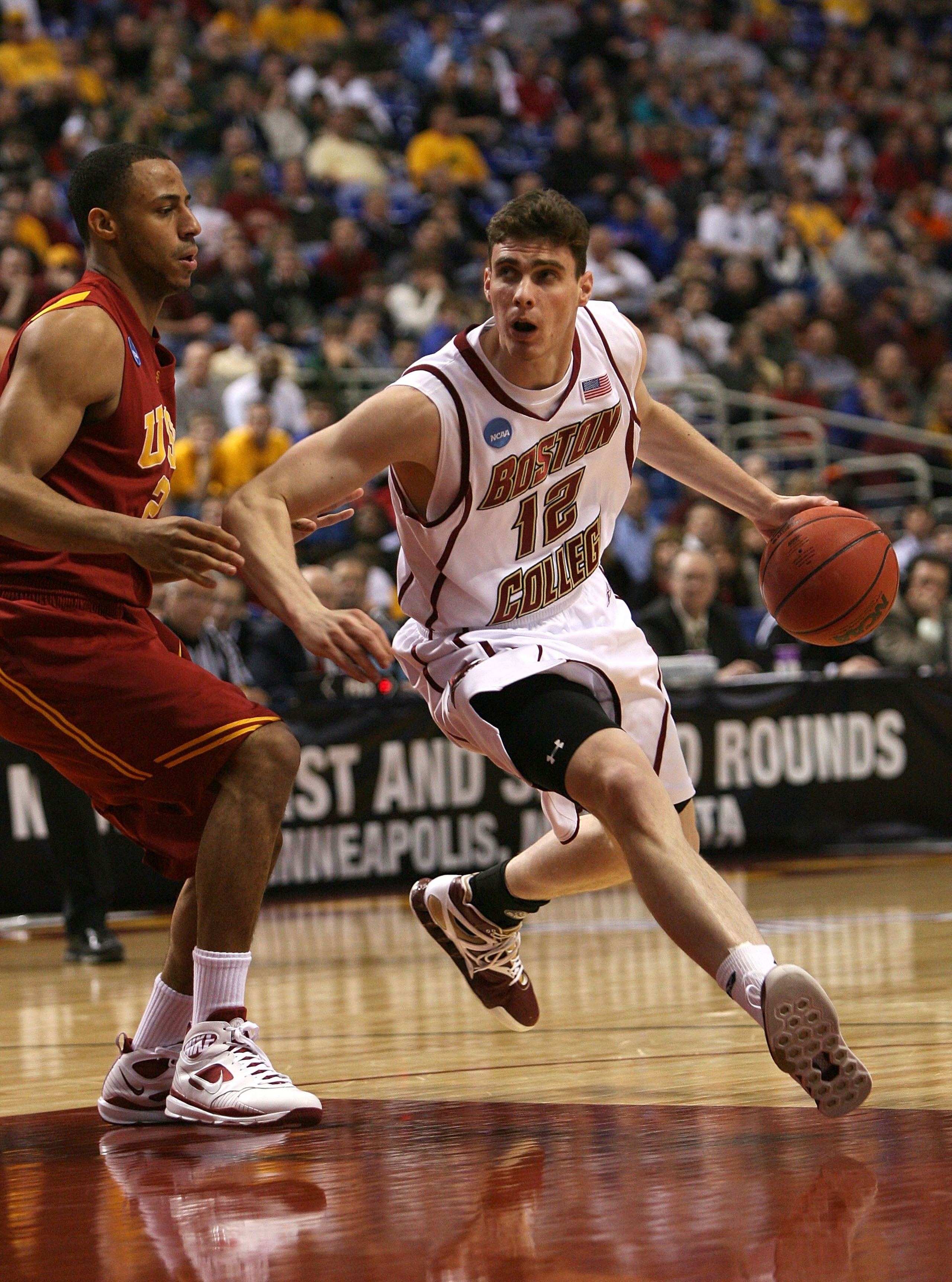 MINNEAPOLIS - MARCH 20:  Joe Trapani #12 of the Boston College Eagles drives against Dwight Lewis #21 of the USC Trojans during the first round of the NCAA Division I Men's Basketball Tournament at the Hubert H. Humphrey Metrodome on March 20, 2009 in Min