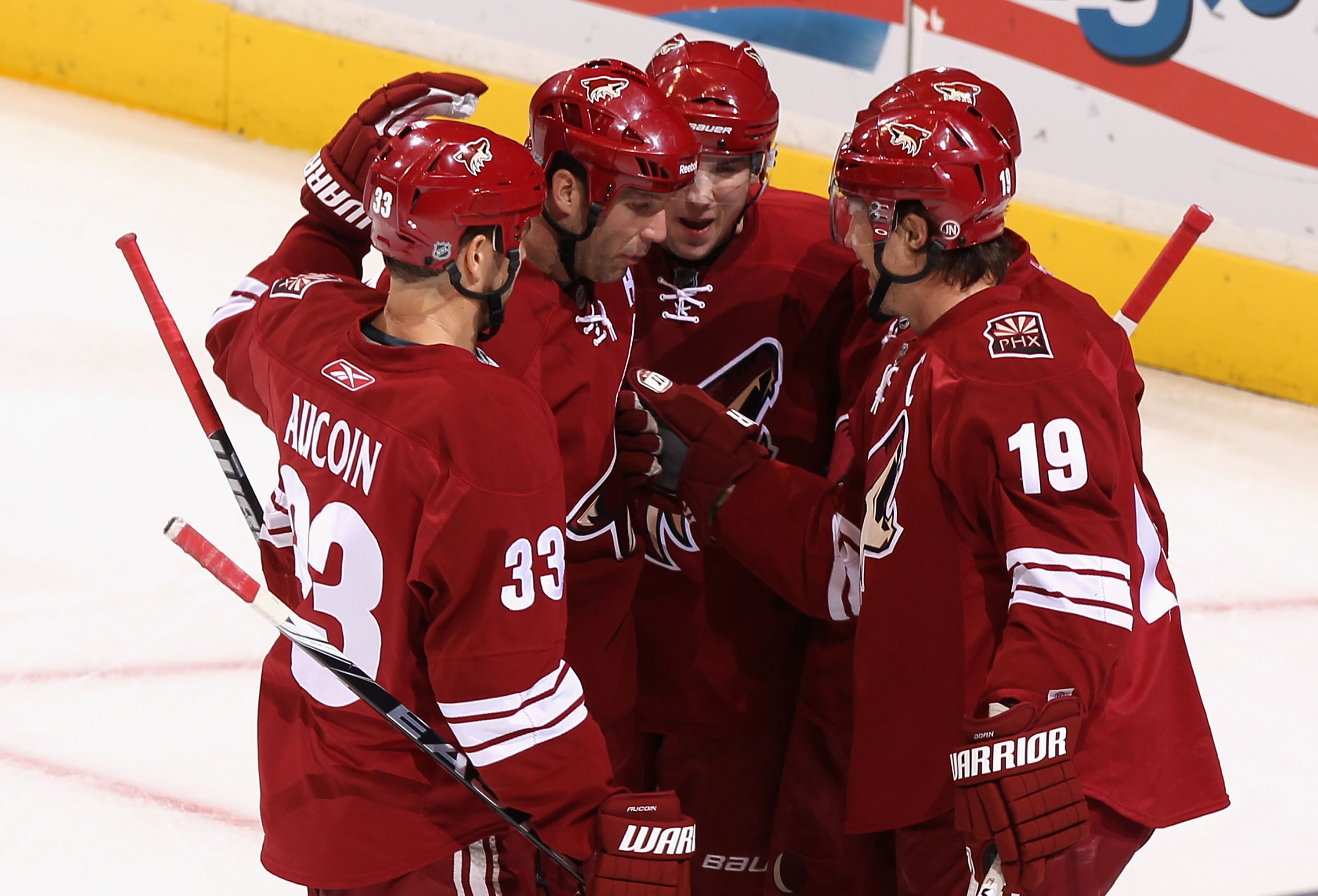 GLENDALE, AZ - DECEMBER 11: Shane Doan #19 (R) of the Phoenix Coyotes celebrates with teammates Adrian Aucoin #33, Ed Jovanovski #55 and Scottie Upshall #8 after Doan scored a first period goal against the Dallas Stars during the NHL game at Jobing.com A