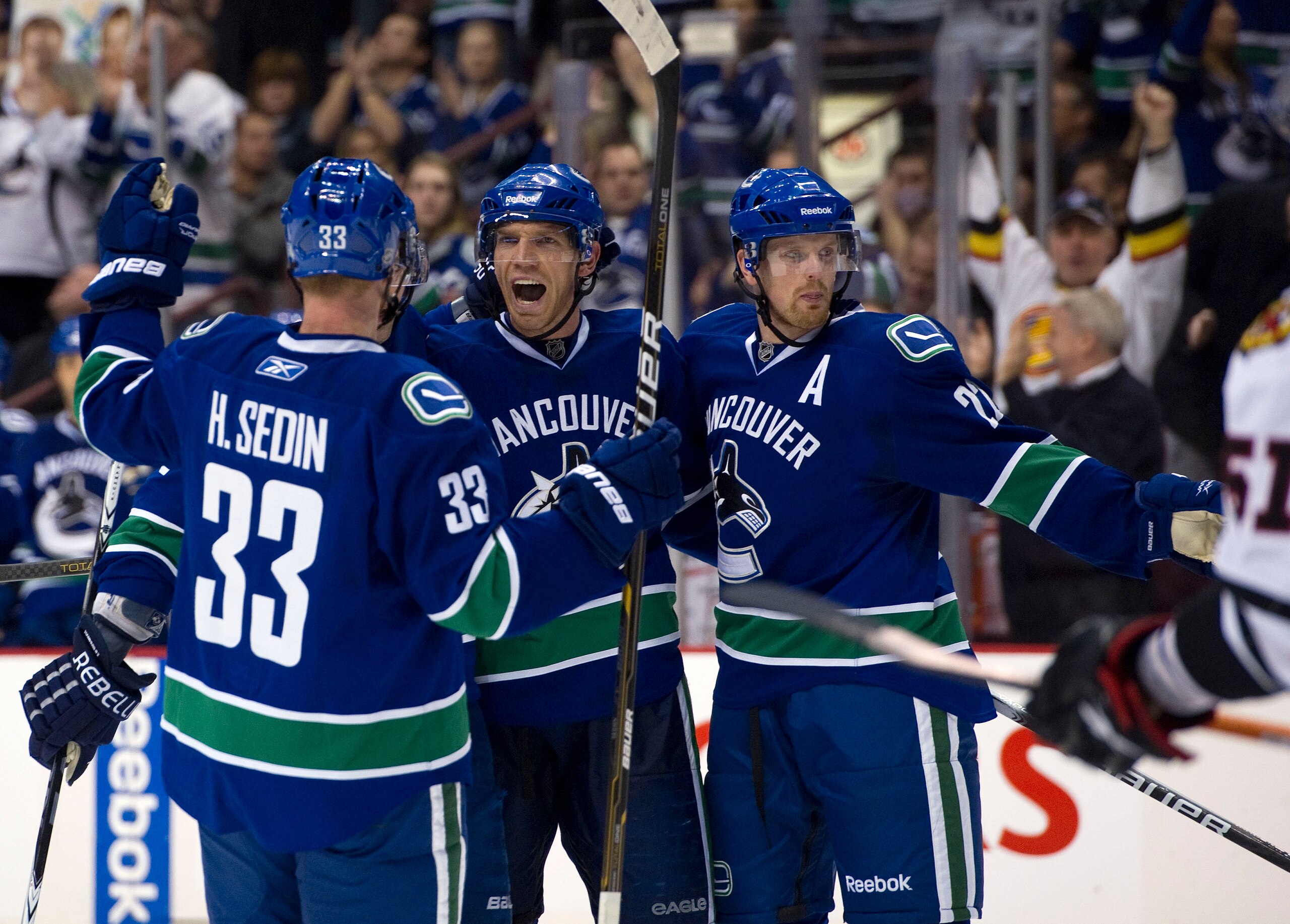 VANCOUVER, CANADA - FEBRUARY 4: Mikael Samuelsson #26 of the Vancouver Canucks celebrates with Henrik Sedin #33 and Daniel Sedin #22 after scoring against the Chicago Blackhawks during the second period in NHL action on February 04, 2011 at Rogers Arena i VANCOUVER, CANADA - FEBRUARY 4: Mikael Samuelsson #26 of the Vancouver Canucks celebrates with Henrik Sedin #33 and Daniel Sedin #22 after scoring against the Chicago Blackhawks during the second period in NHL action on February 04, 2011 at Rogers Arena i