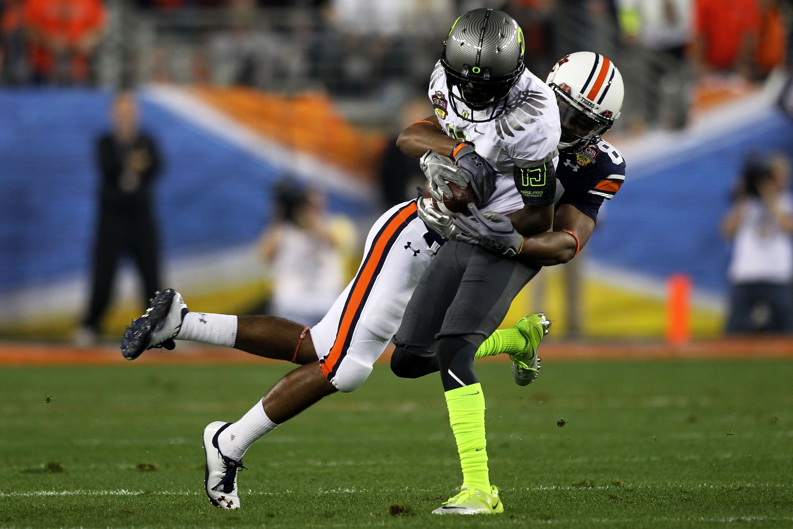 GLENDALE, AZ - JANUARY 10:  Cliff Harris #13 of the Oregon Ducks intercepts a pass in the first quarter as he is tackled by Emory Blake #80 of the Auburn Tigers during the Tostitos BCS National Championship Game at University of Phoenix Stadium on January