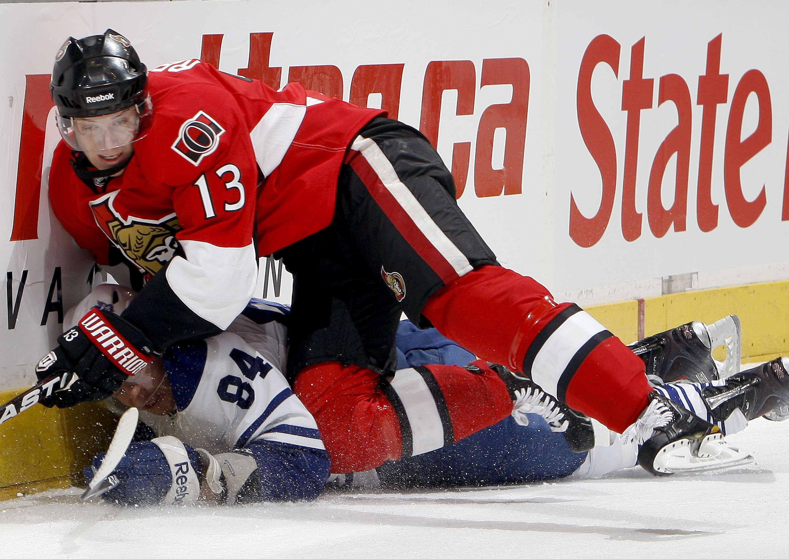 TORONTO, CANADA - FEBRUARY 19: Mikhail Grabovski #84 of the Toronto Maple Leafs gets hit by Peter Regin #13 of the Ottawa Senators at the Air Canada Centre February 19, 2011 in Toronto, Ontario, Canada. (Photo by Abelimages/Getty Images)