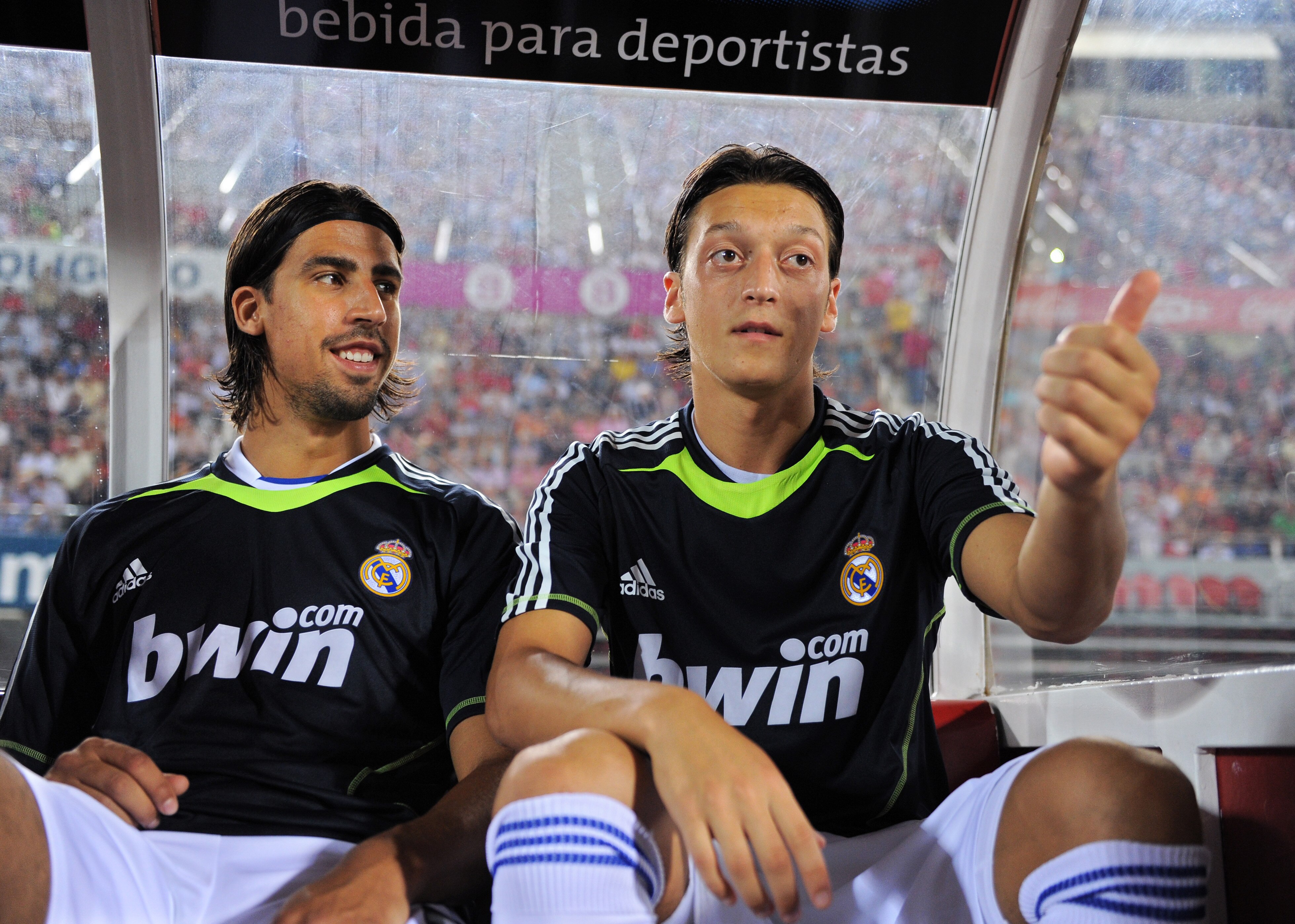PALMA DE MALLORCA, SPAIN - AUGUST 29:  Mesut Ozil (R) of Real Madrid jokes while seated on the bench flanked by his teammate and fellow countryman Sami Khedira during the La Liga match between Mallorca and Real Madrid at the ONO Estadio on August 29, 2010