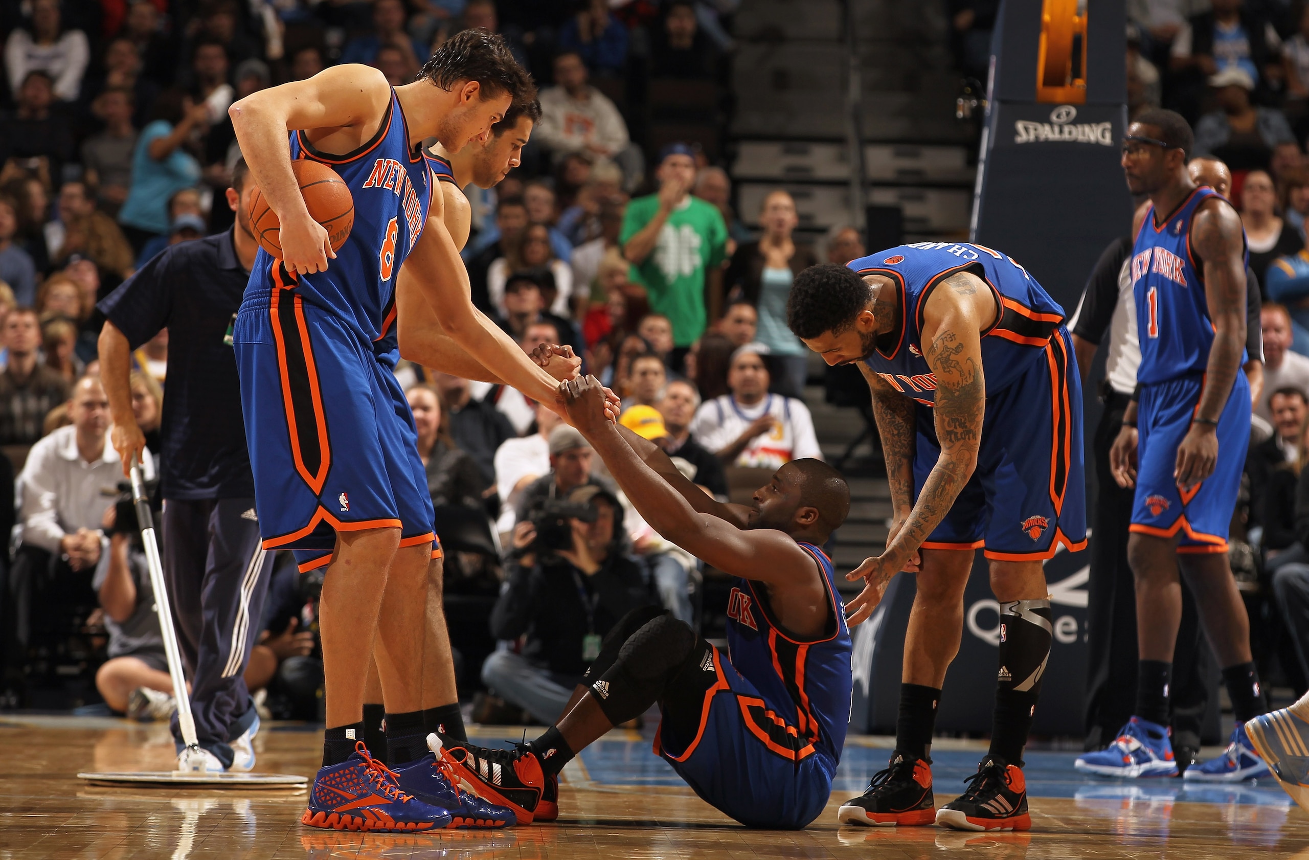 DENVER - NOVEMBER 16:  Raymond Felton #2 of the New York Knicks is helped up by teammates Danilo Gallinari #8, Landry Fields #6 and Wilson Chandler #21 after being fouled as Amar'e Stoudemire #1 looks on against the Denver Nuggets at the Pepsi Center on N