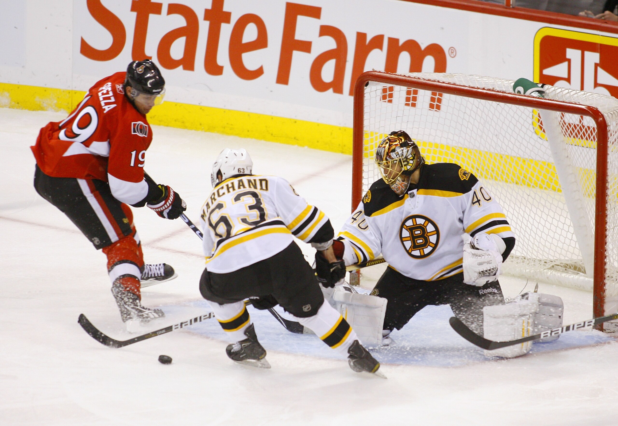 OTTAWA, ON - FEBRUARY 18:  Tuukka Rask #40 of the Boston Bruins kicks out a pad save to teammate Brad Marchand #63 while Jason Spezza #19 of the Ottawa Senators tries to get a stick on the puck during a game at Scotiabank Place on February 18, 2011 in Ott