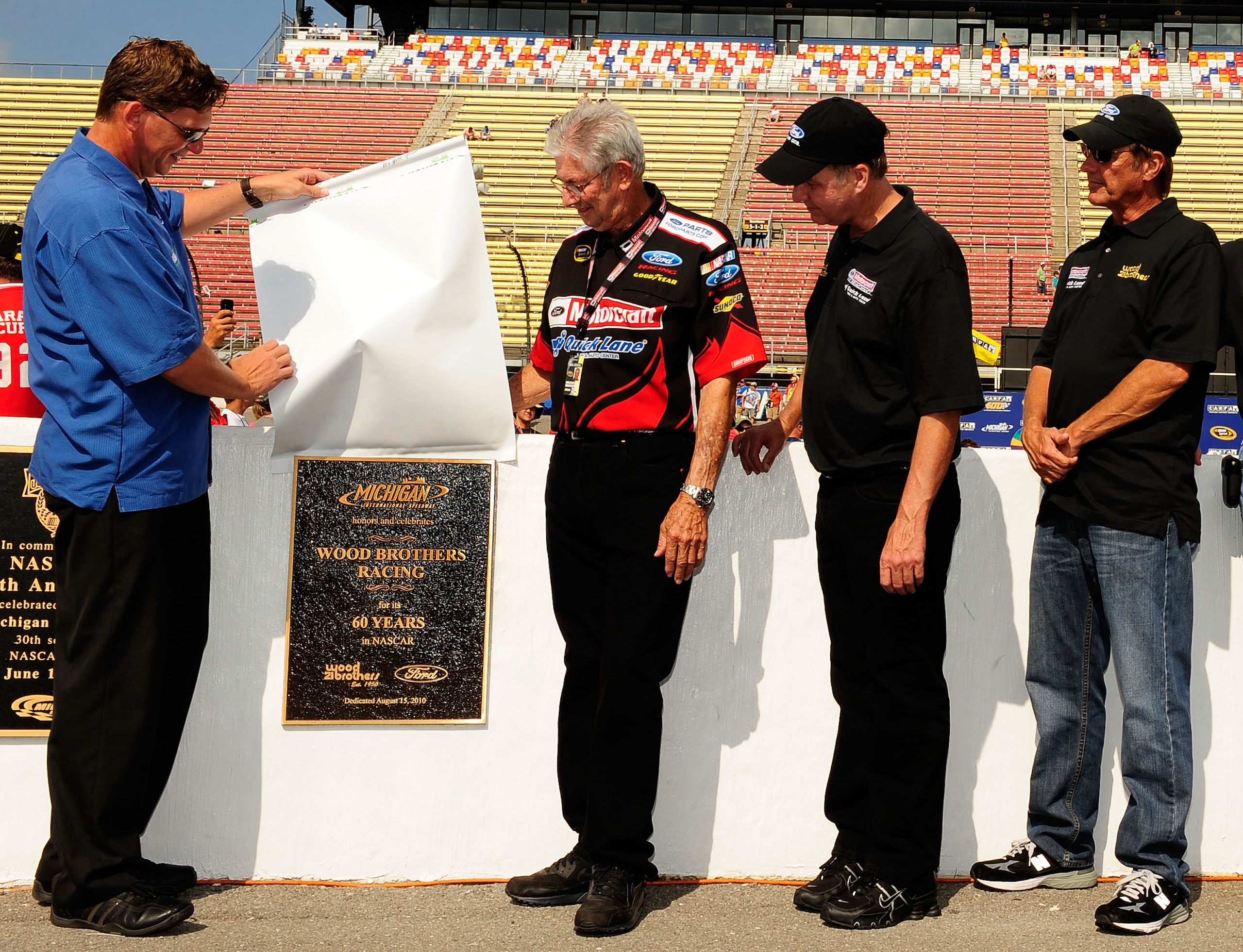 BROOKLYN, MI - AUGUST 15: (L-R) MIS President Roger Curtis unveils a permanent plaque celebrating the 60th Anniversary of Wood Brothers Racing in NASCAR as Leonard Wood, Eddie Wood and Len Wood watch prior to the running of the NASCAR Sprint Cup Series C BROOKLYN, MI - AUGUST 15: (L-R) MIS President Roger Curtis unveils a permanent plaque celebrating the 60th Anniversary of Wood Brothers Racing in NASCAR as Leonard Wood, Eddie Wood and Len Wood watch prior to the running of the NASCAR Sprint Cup Series C