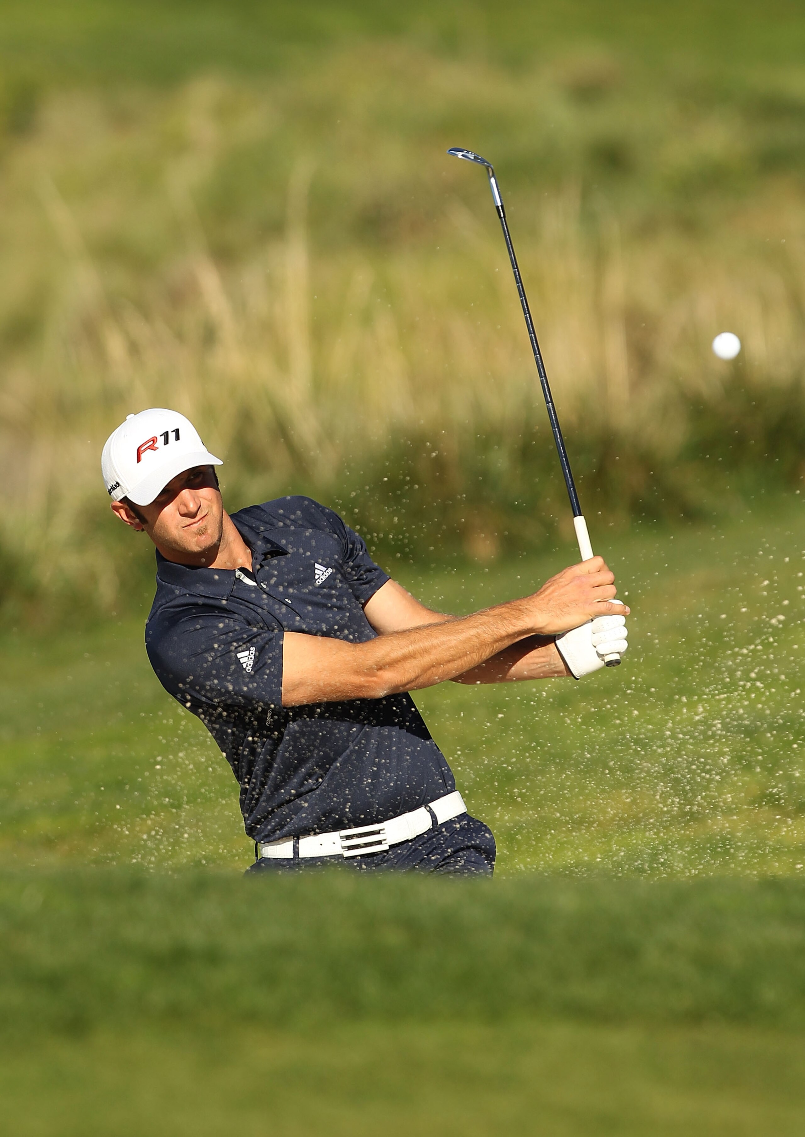 PEBBLE BEACH, CA - FEBRUARY 12:  Dustin Johnson hits out of the bunker on the 5th hole during the third round of the AT&T Pebble Beach National Pro-Am at the Pebble Beach Golf Links on February 12, 2011 in Pebble Beach, California  (Photo by Ezra Shaw/Get