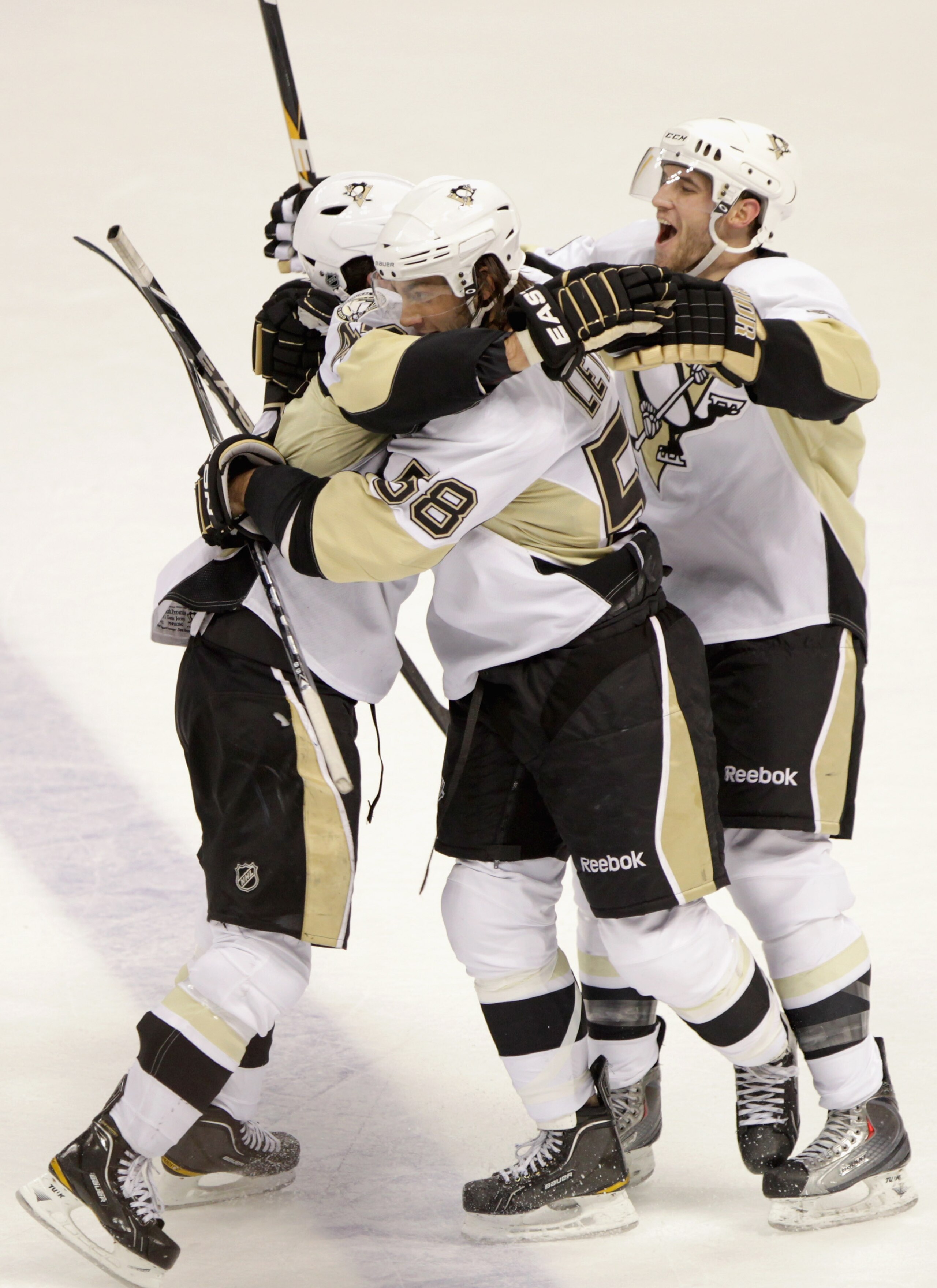 DENVER, CO - FEBRUARY 16:  Tyler Kennedy #48 (L) of the Pittsburgh Penguins celebrates his game winning goal in overtime with Kris Letang #58 and Alex Goligoski #3 against the Colorado Avalanche at the Pepsi Center on February 16, 2011 in Denver, Colorado