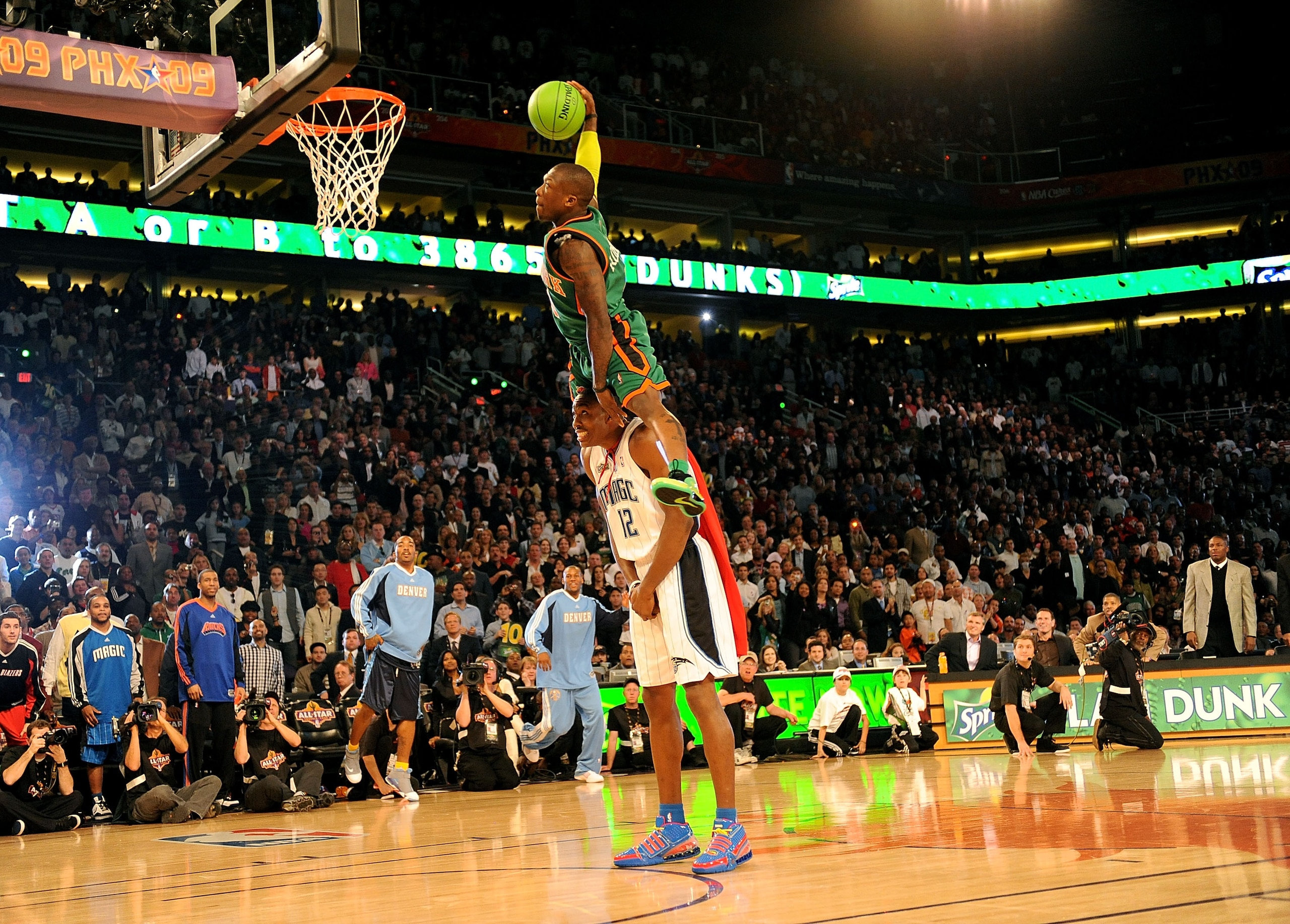 PHOENIX - FEBRUARY 14:  Nate Robinson of the New York Knicks leaps over Dwight Howard of the Orlando Magic in the finals of the Sprite Slam Dunk Contest on All-Star Saturday Night, part of 2009 NBA All-Star Weekend at US Airways Center on February 14, 200