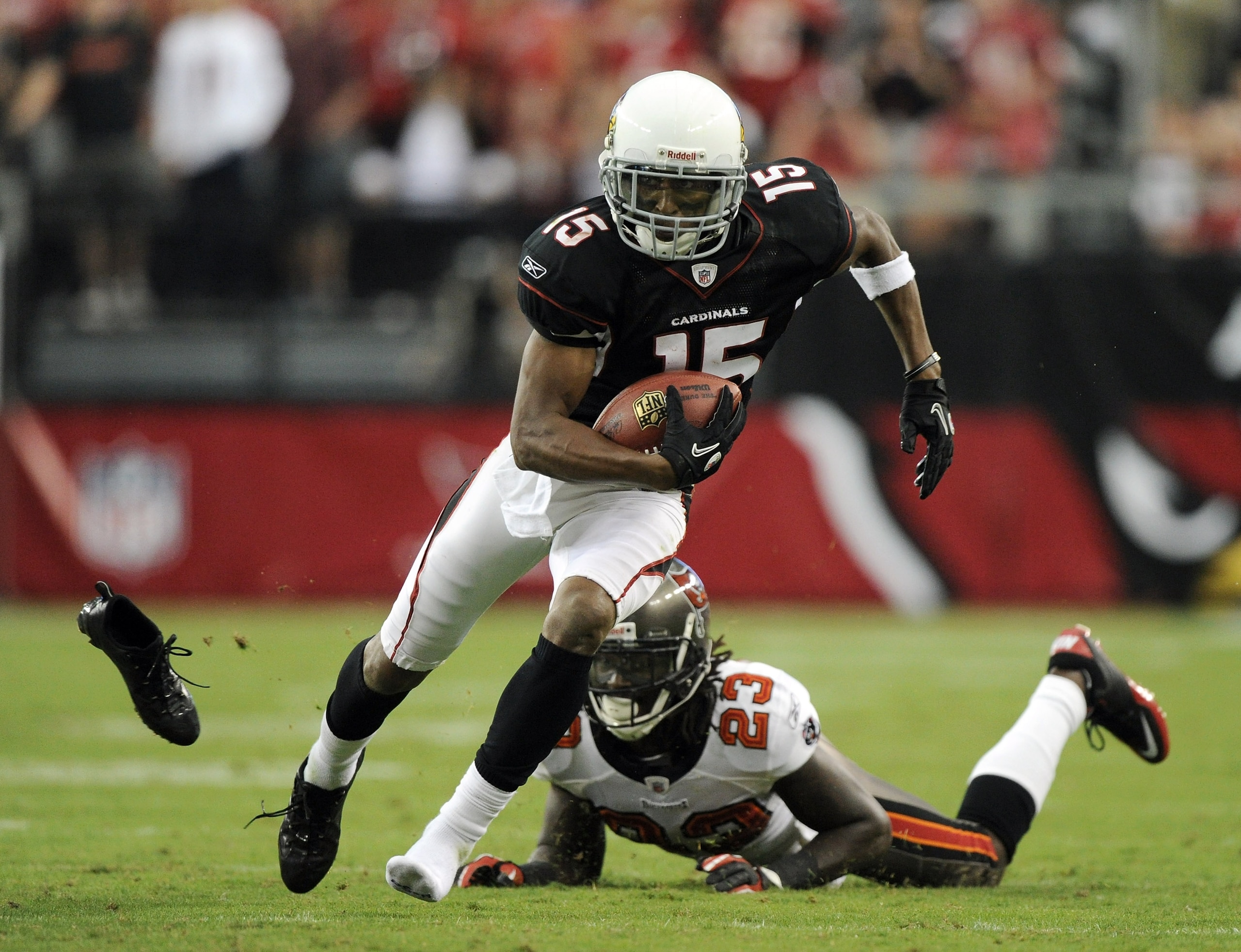 GLENDALE, AZ - OCTOBER 31:  Steve Breaston #15 of the Arizona Cardinals loses a shoe as he eludes the tackle from Myron Lewis #23 of the Tampa Bay Buccaneers during the fourth quarter at University of Phoenix Stadium on October 31, 2010 in Glendale, Arizo