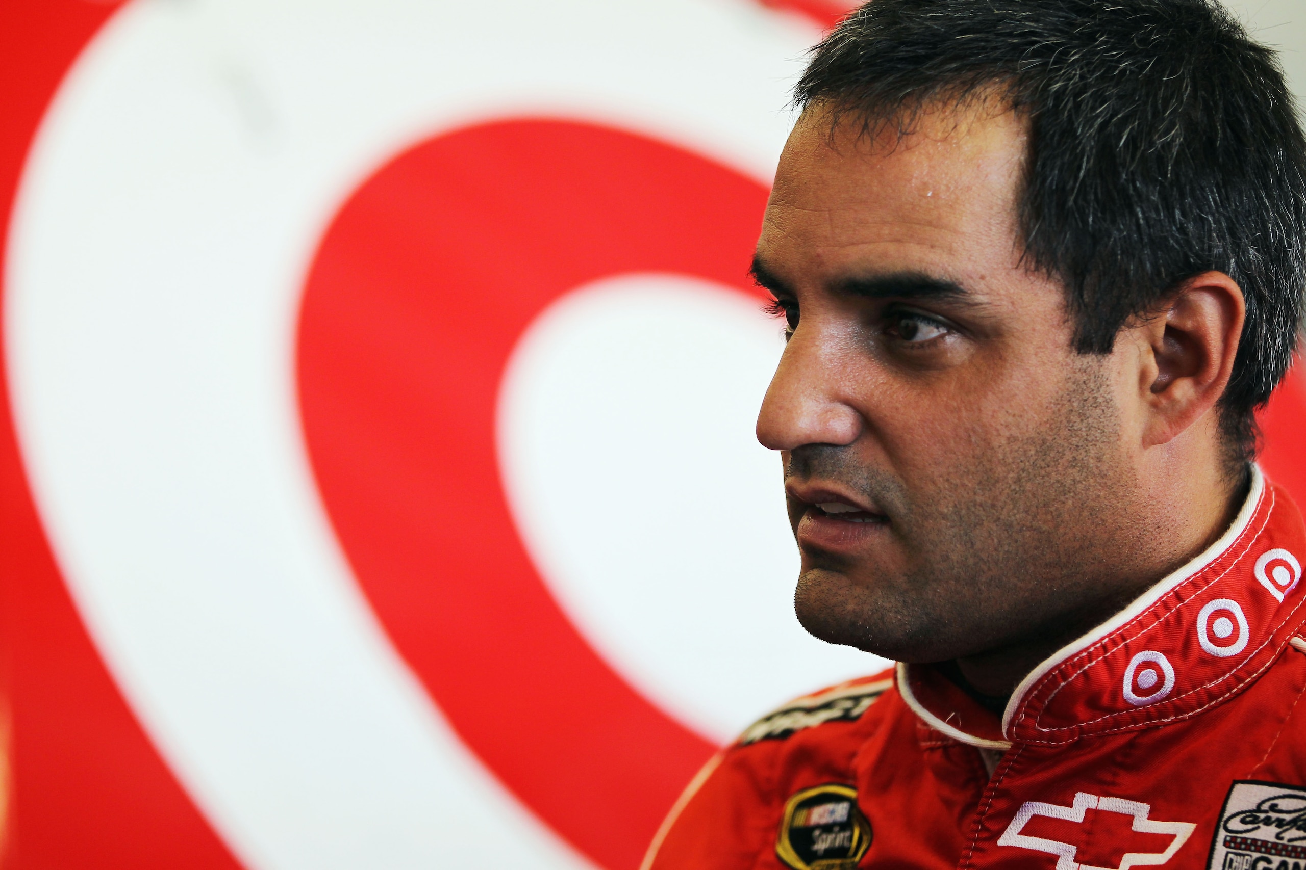 DAYTONA BEACH, FL - FEBRUARY 19:  Juan Pablo Montoya, driver of the #42 Target Chevrolet, stands in the garage during practice for the NASCAR Sprint Cup Series Daytona 500 at Daytona International Speedway on February 19, 2011 in Daytona Beach, Florida.  