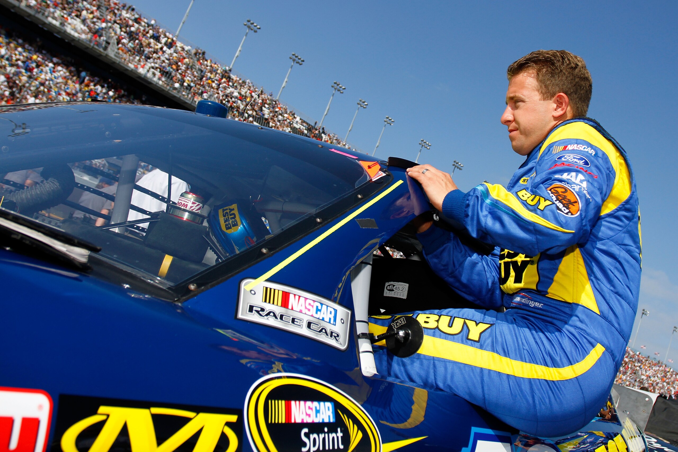 DAYTONA BEACH, FL - FEBRUARY 17:  A.J. Allmendinger climbs into the #43 Best Buy Ford during the first race of the NASCAR Sprint Cup Series Gatorade Duel at Daytona International Speedway on February 17, 2011 in Daytona Beach, Florida.  (Photo by Jason Sm