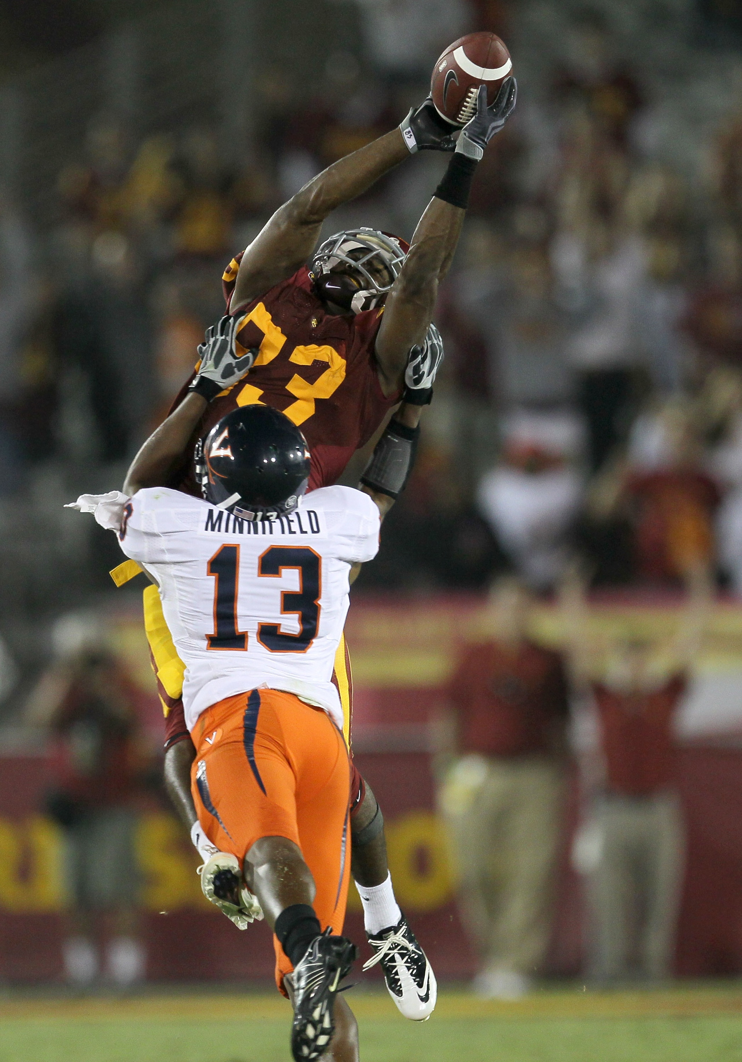 LOS ANGELES, CA - SEPTEMBER 11: Wide receiver Ronald Johnson #83 of the USC Trojans reaches for the ball over cornerback Chase Minnifield #13 of the Virginia Cavaliers at Los Angeles Memorial Coliseum on September 11, 2010 in Los Angeles, California. USC LOS ANGELES, CA - SEPTEMBER 11: Wide receiver Ronald Johnson #83 of the USC Trojans reaches for the ball over cornerback Chase Minnifield #13 of the Virginia Cavaliers at Los Angeles Memorial Coliseum on September 11, 2010 in Los Angeles, California. USC