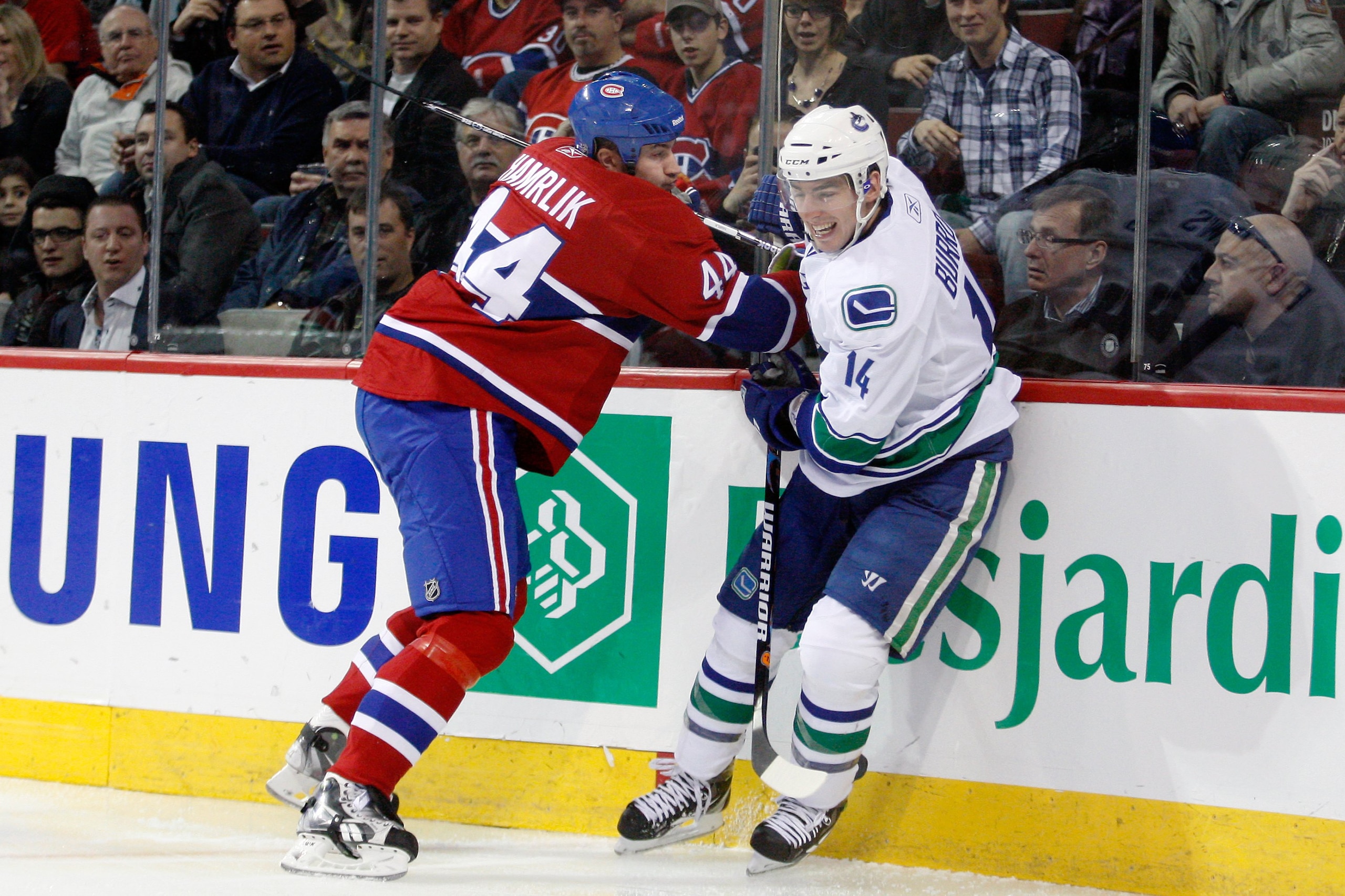 MONTREAL- NOVEMBER 9:  Roman Hamrlik #44 of the Montreal Canadiens body cehcks Alex Burrows #14 of the Vancouver Canucks during the NHL game at the Bell Centre on November 9, 2010 in Montreal, Quebec, Canada.  The Canadiens defeated the Canucks 2-0.  (Pho