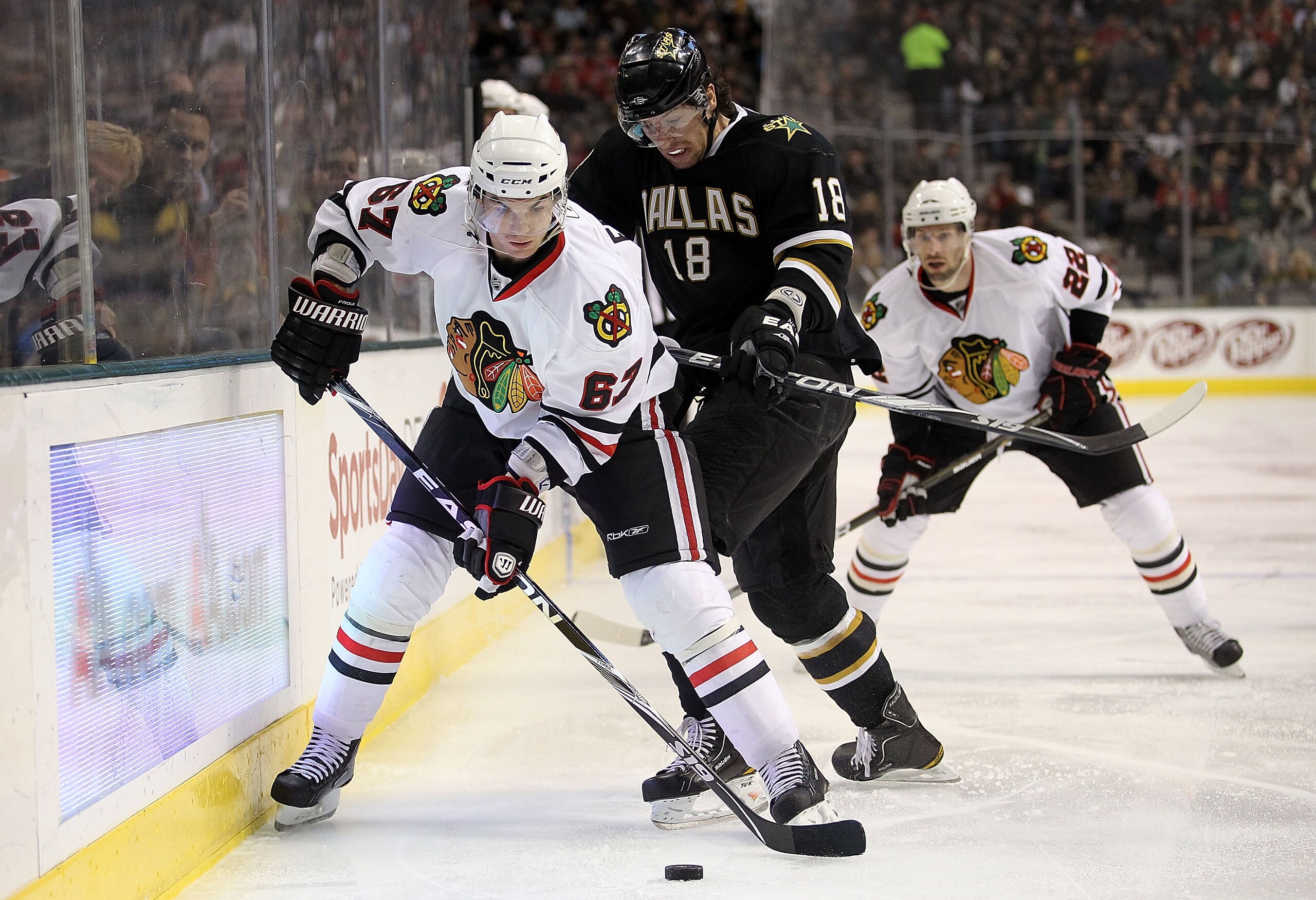 DALLAS, TX - FEBRUARY 11:  Right wing Michael Frolik #57 of the Chicago Blackhawks skates the puck against James Neal #18 of the Dallas Stars at American Airlines Center on February 11, 2011 in Dallas, Texas.  (Photo by Ronald Martinez/Getty Images)