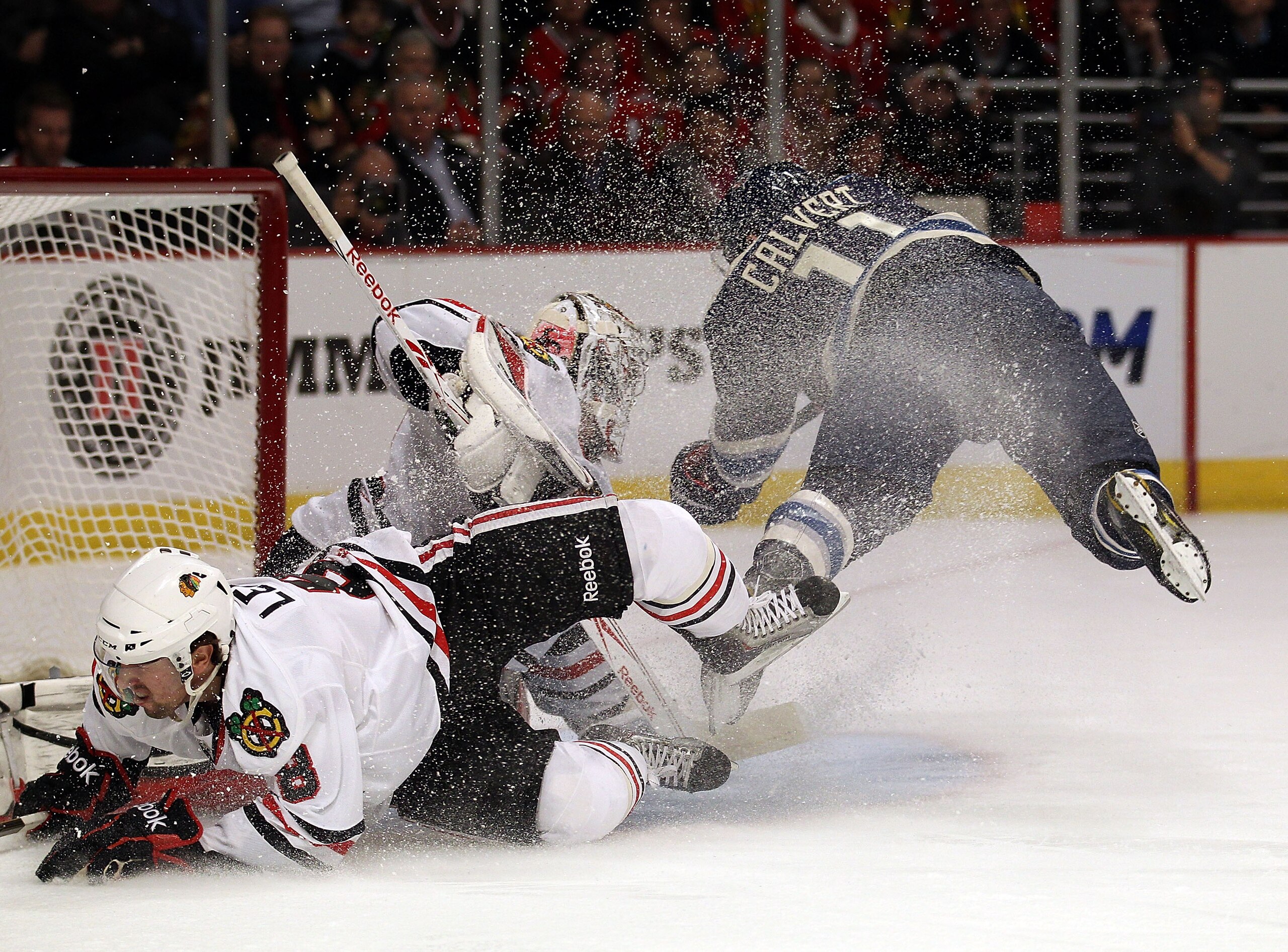 CHICAGO, IL - FEBRUARY 18: Matt Calvert #11 of the Columbus Blue Jackets collides with Nick Leddy #8 and Corey Crawford #50 of the Chicago Blackhawks as he scores a 1st period goal at the United Center on February 18, 2011 in Chicago, Illinois. (Photo by