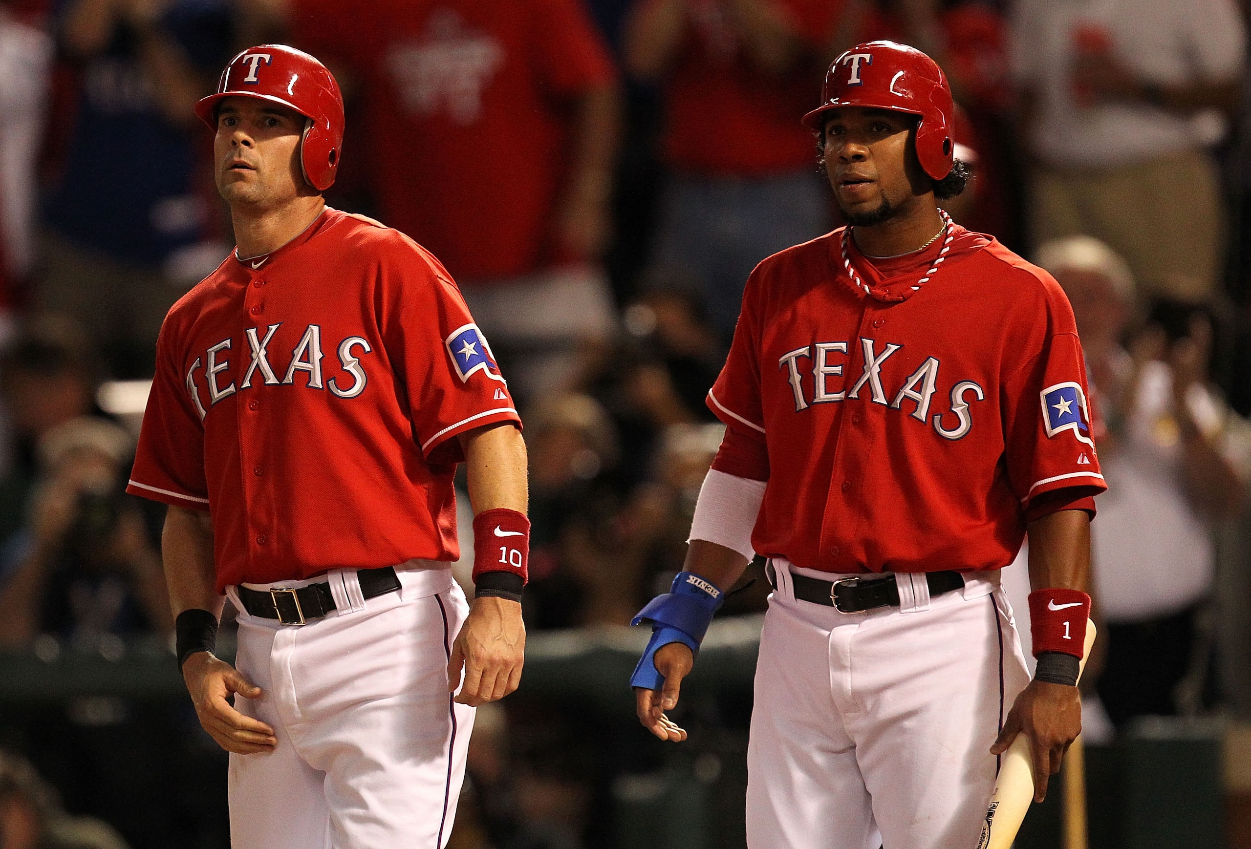 ARLINGTON, TX - OCTOBER 15:  Elvis Andrus #1 (R) and Michael Young #10 of the Texas Rangers wait for Josh Hamilton after they scored on Hamilton's 3-run home run in the first inning against the New York Yankees in Game One of the ALCS during the 2010 MLB