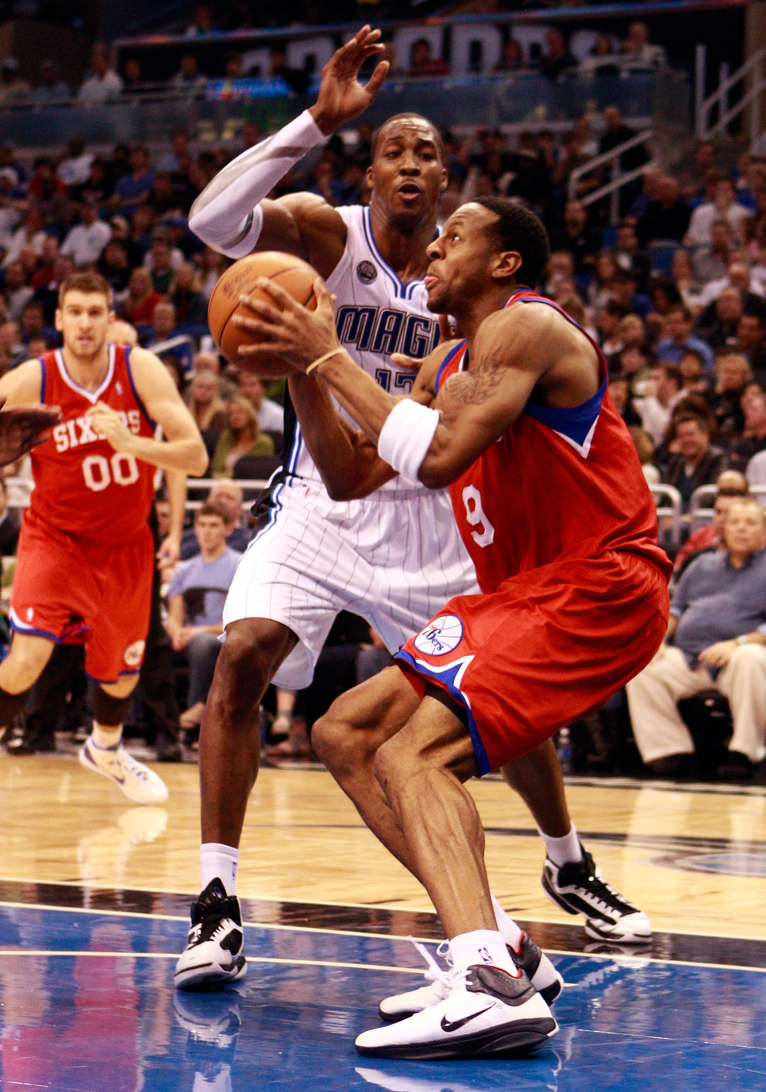 ORLANDO, FL - DECEMBER 18:  Andre Iguodala #9 of the Philadelphia 76ers attempts a shot against Dwight Howard #12 of the Orlando Magic during the game at Amway Arena on December 18, 2010 in Orlando, Florida.  NOTE TO USER: User expressly acknowledges and