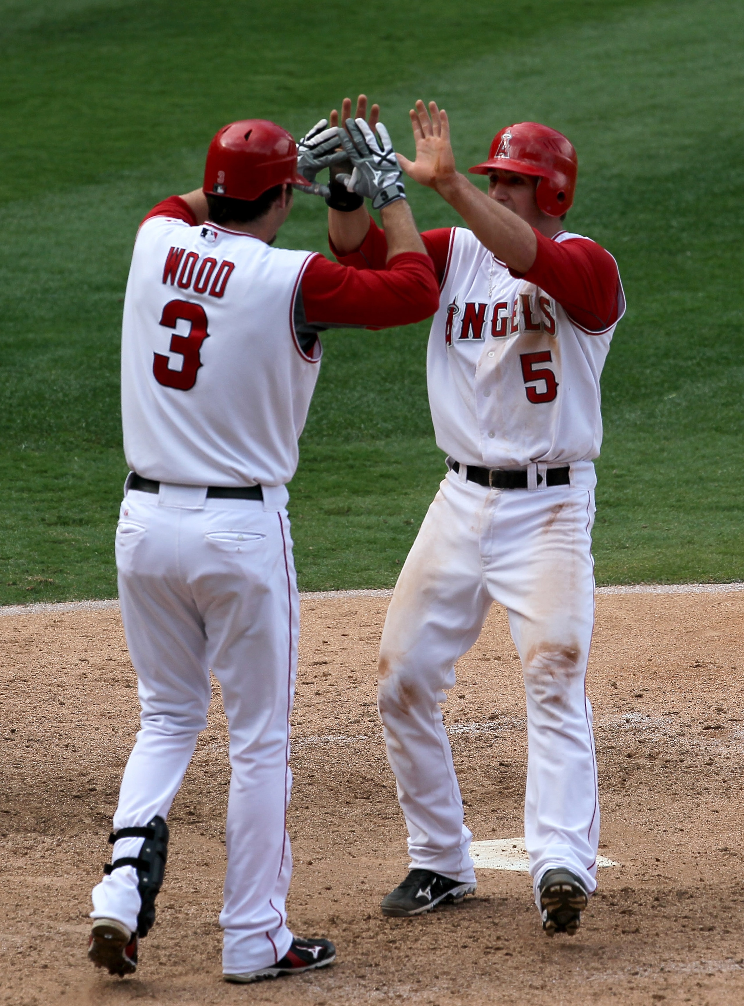 ANAHEIM, CA - SEPTEMBER 29:   Jeff Mathis #5 of the Los Angeles Angels of Anaheim is greeted by Brandon Wood #3 of the Oakland Athletics as Mathis scores the winning run on September 29, 2010 at Angel Stadium in Anaheim, California. The Angels won 2-1 in