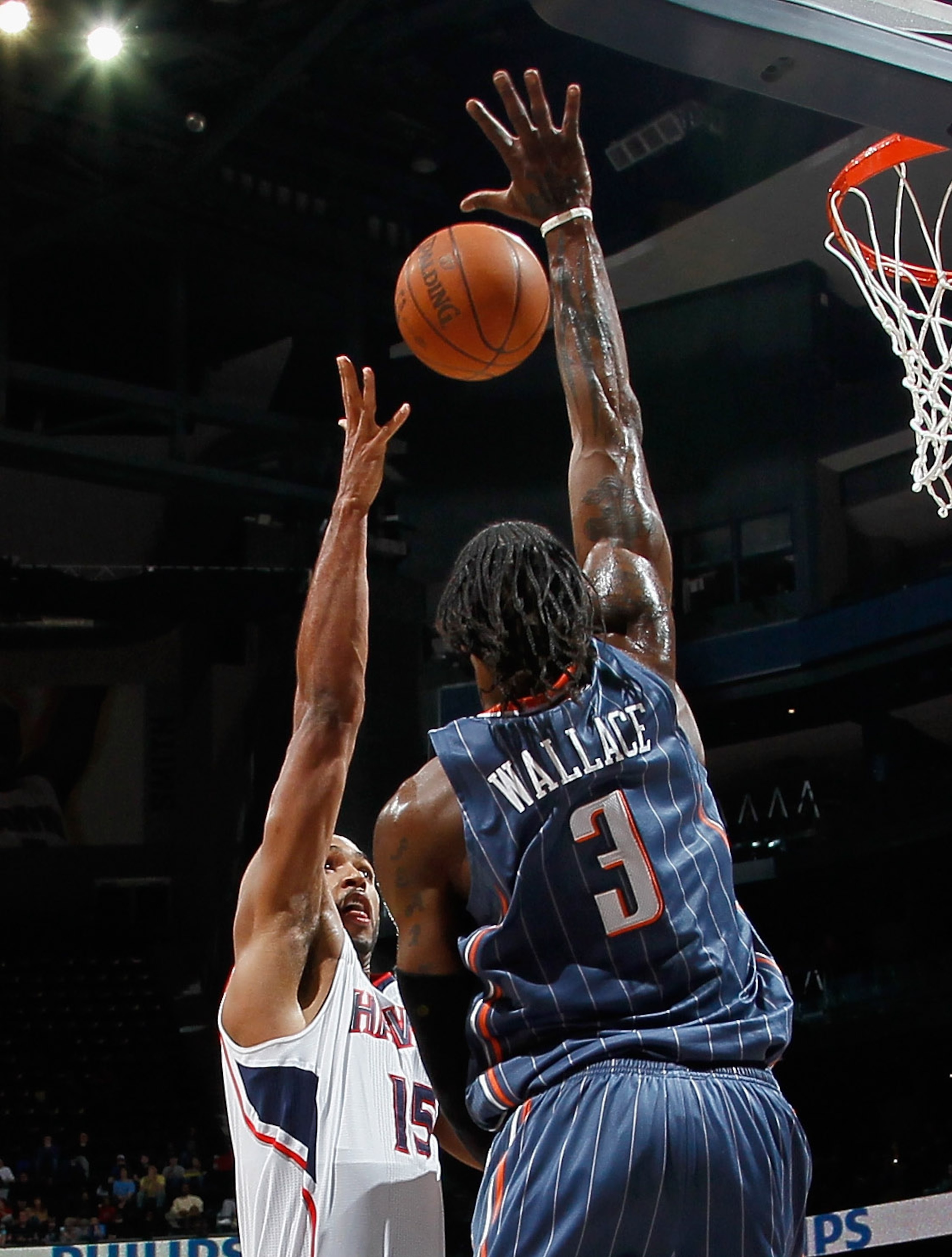 ATLANTA, GA - FEBRUARY 12:  Al Horford #15 of the Atlanta Hawks has his shot blocked by Gerald Wallace #3 of the Charlotte Bobcats at Philips Arena on February 12, 2011 in Atlanta, Georgia.  NOTE TO USER: User expressly acknowledges and agrees that, by do