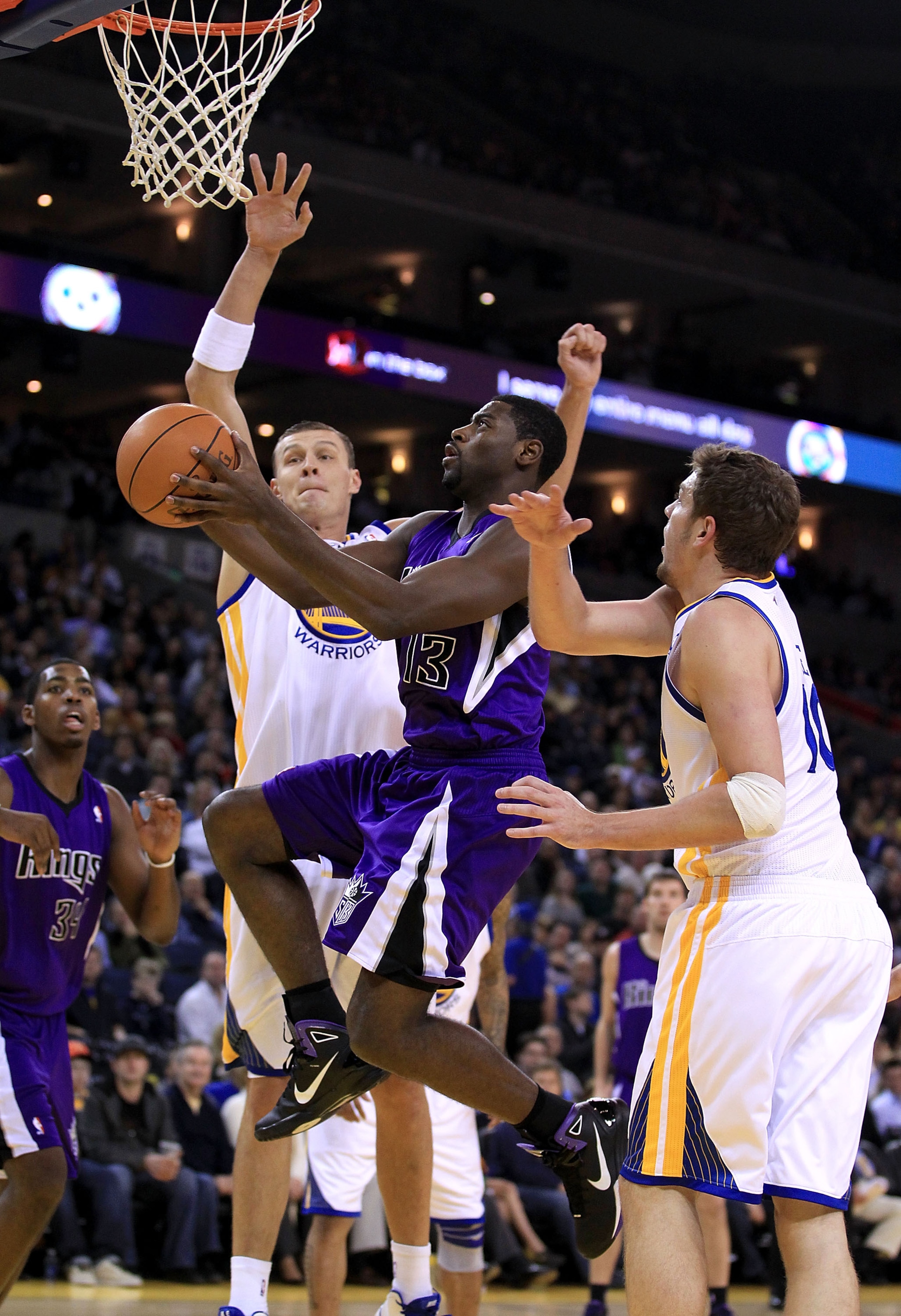 OAKLAND, CA - JANUARY 21: Tyreke Evans #13 of the Sacramento Kings drives to the basket between Andris Biedrins #15 and David Lee #10 of the Golden State Warriors at Oracle Arena on January 21, 2011 in Oakland, California. NOTE TO USER: User expressly ac OAKLAND, CA - JANUARY 21: Tyreke Evans #13 of the Sacramento Kings drives to the basket between Andris Biedrins #15 and David Lee #10 of the Golden State Warriors at Oracle Arena on January 21, 2011 in Oakland, California. NOTE TO USER: User expressly ac
