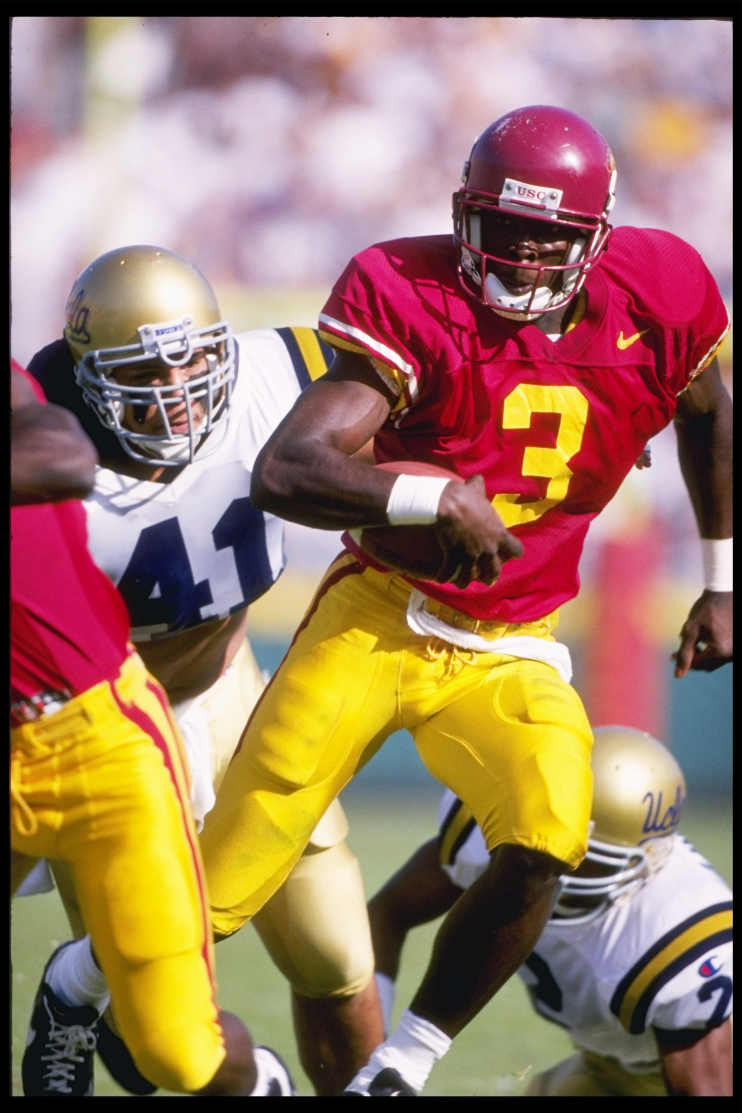 18 Nov 1995:  Wide receiver Keyshawn Johnson of the Southern California Trojans runs down the field as linebacker Jason Nevadowsky of the California at Los Angeles Bruins chases after him at the Los Angeles Memorial Coliseum in Los Angeles, California.  C