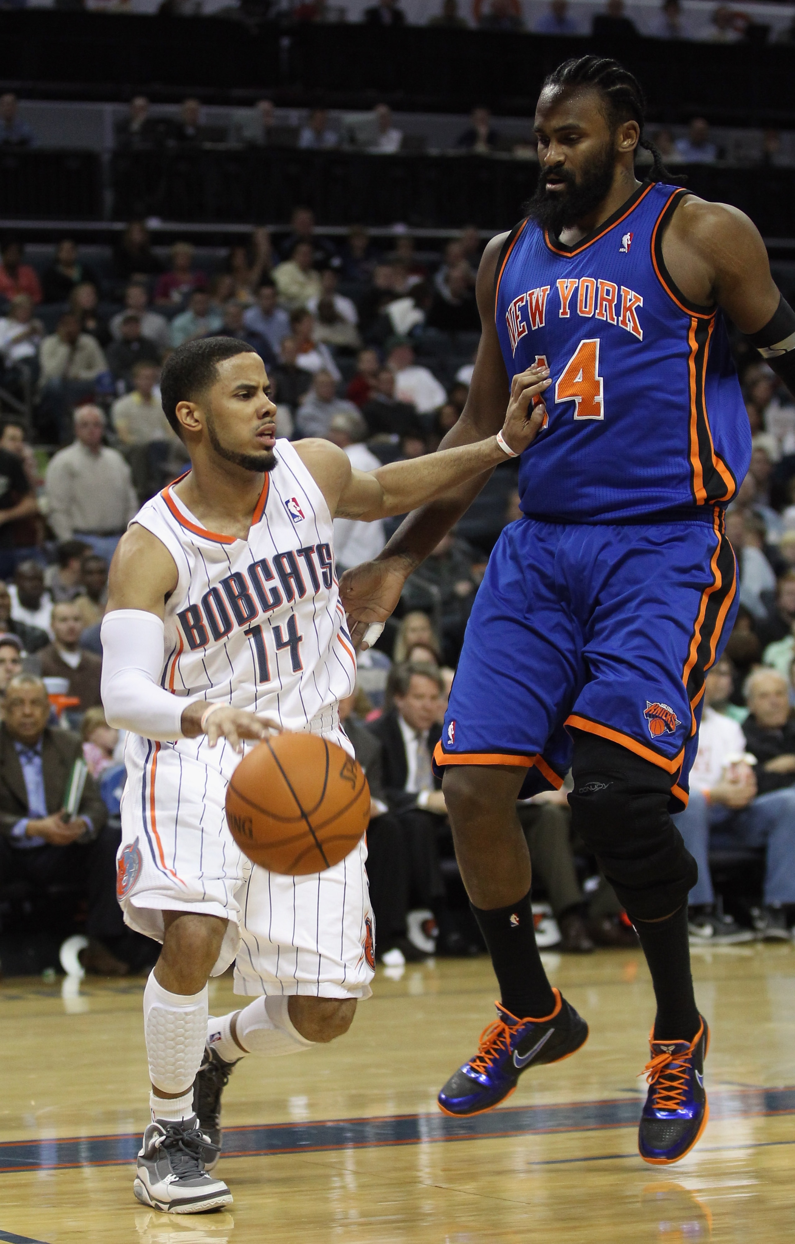 CHARLOTTE, NC - NOVEMBER 24:  Ronny Turiaf #4 of the New York Knicks guards D.J. Augustin #14 of the Charlotte Bobcats during their game at Time Warner Cable Arena on November 24, 2010 in Charlotte, North Carolina.  NOTE TO USER: User expressly acknowledg