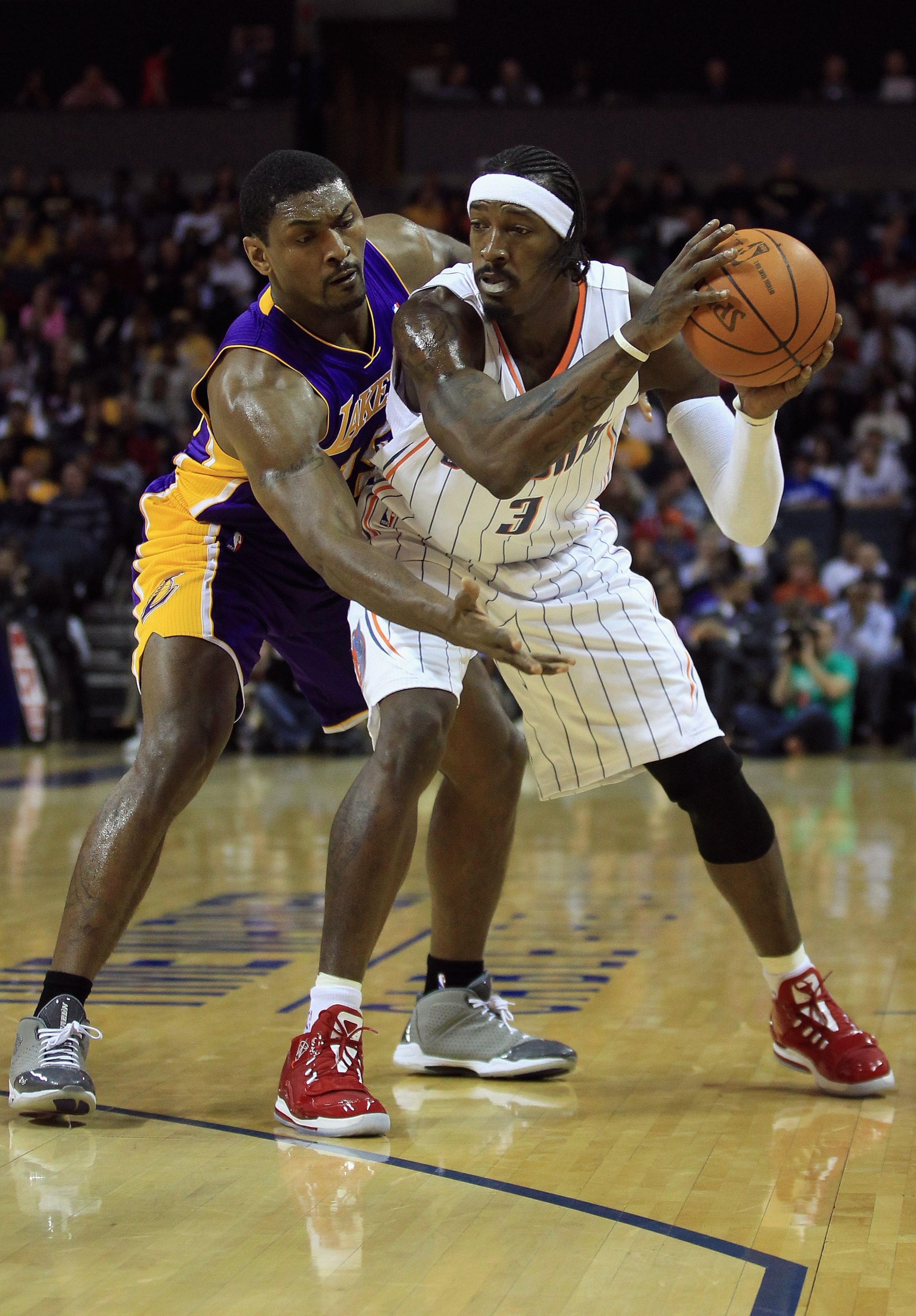 CHARLOTTE, NC - FEBRUARY 14:  Ron Artest #15 of the Los Angeles Lakers reaches for the ball against Gerald Wallace #3 of the Charlotte Bobcats during their game at Time Warner Cable Arena on February 14, 2011 in Charlotte, North Carolina. NOTE TO USER: Us