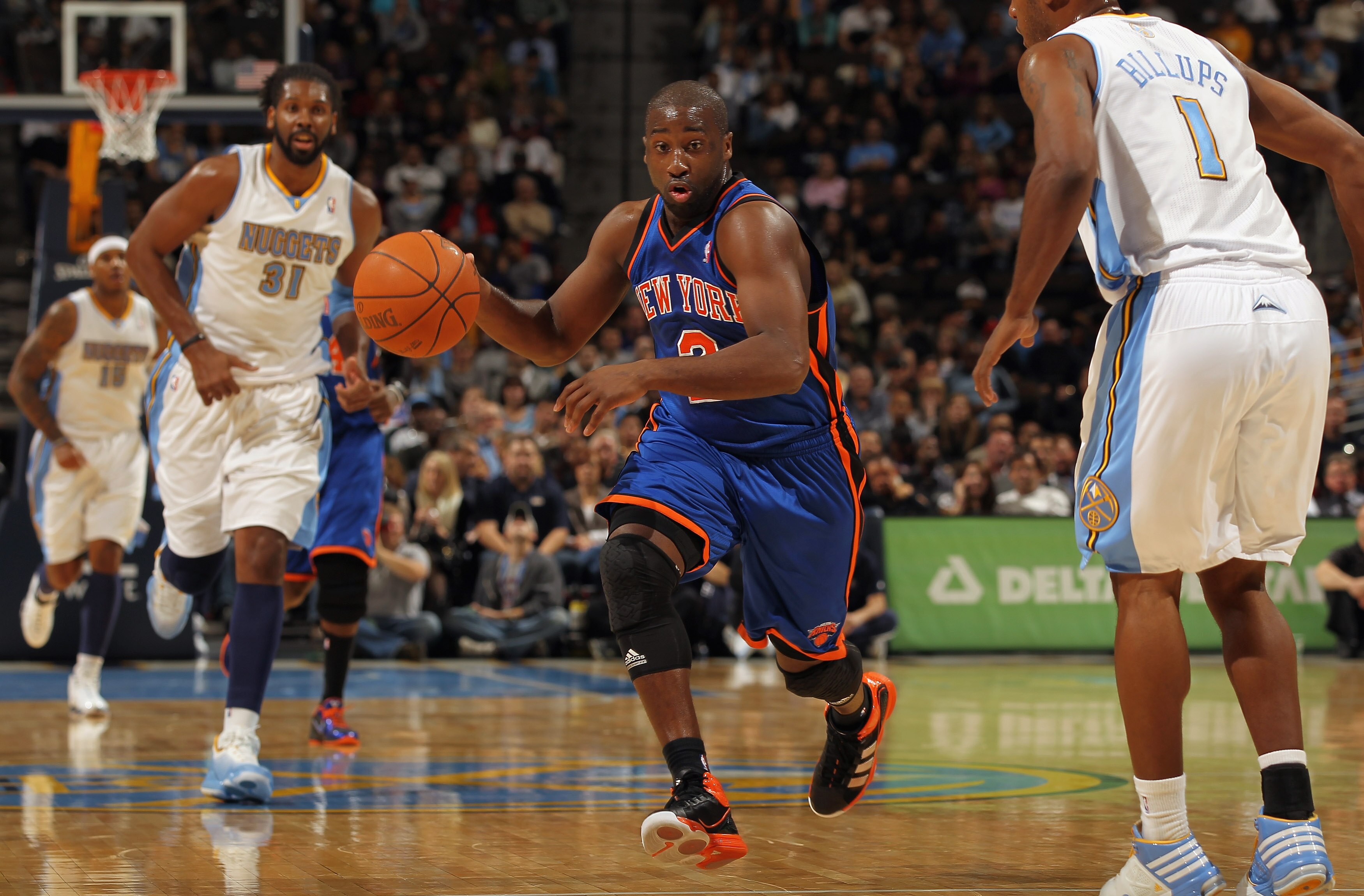 DENVER - NOVEMBER 16:  Raymond Felton #2 of the New York Knicks drives with the ball between Nene #31 and Chauncey Billups #1 of the Denver Nuggets defends at the Pepsi Center on November 16, 2010 in Denver, Colorado. NOTE TO USER: User expressly acknowle