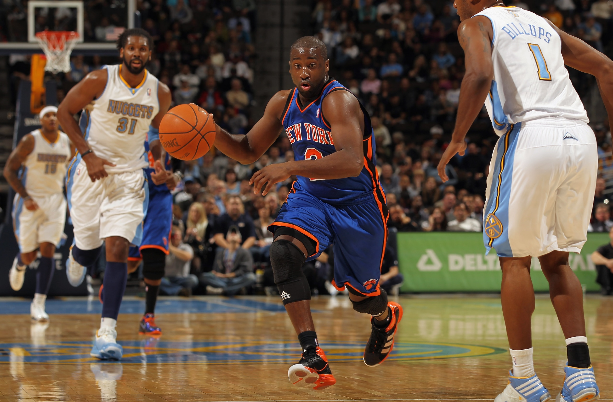 DENVER - NOVEMBER 16:  Raymond Felton #2 of the New York Knicks drives with the ball between Nene #31 and Chauncey Billups #1 of the Denver Nuggets defends at the Pepsi Center on November 16, 2010 in Denver, Colorado. NOTE TO USER: User expressly acknowle