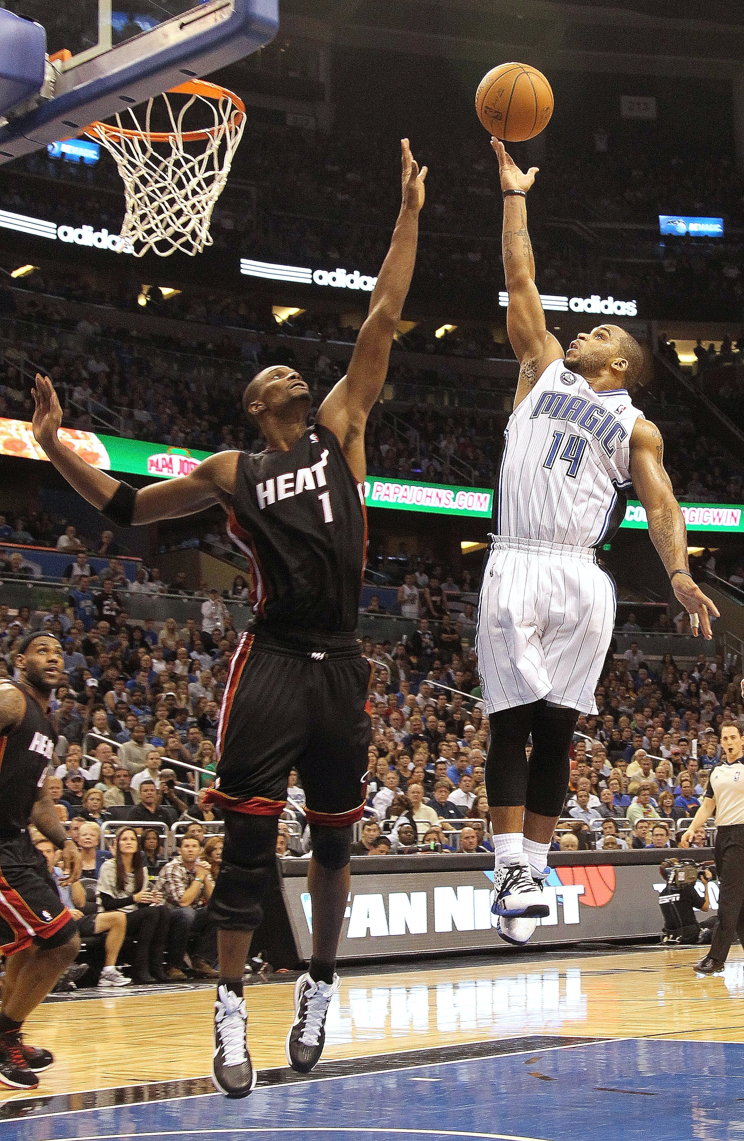 ORLANDO, FL - NOVEMBER 24:  Jameer Nelson #14 of the Orlando Magic shoots over Chris Bosh #1 of the Miami Heat during a game at Amway Arena on November 24, 2010 in Orlando, Florida. NOTE TO USER: User expressly acknowledges and agrees that, by downloading