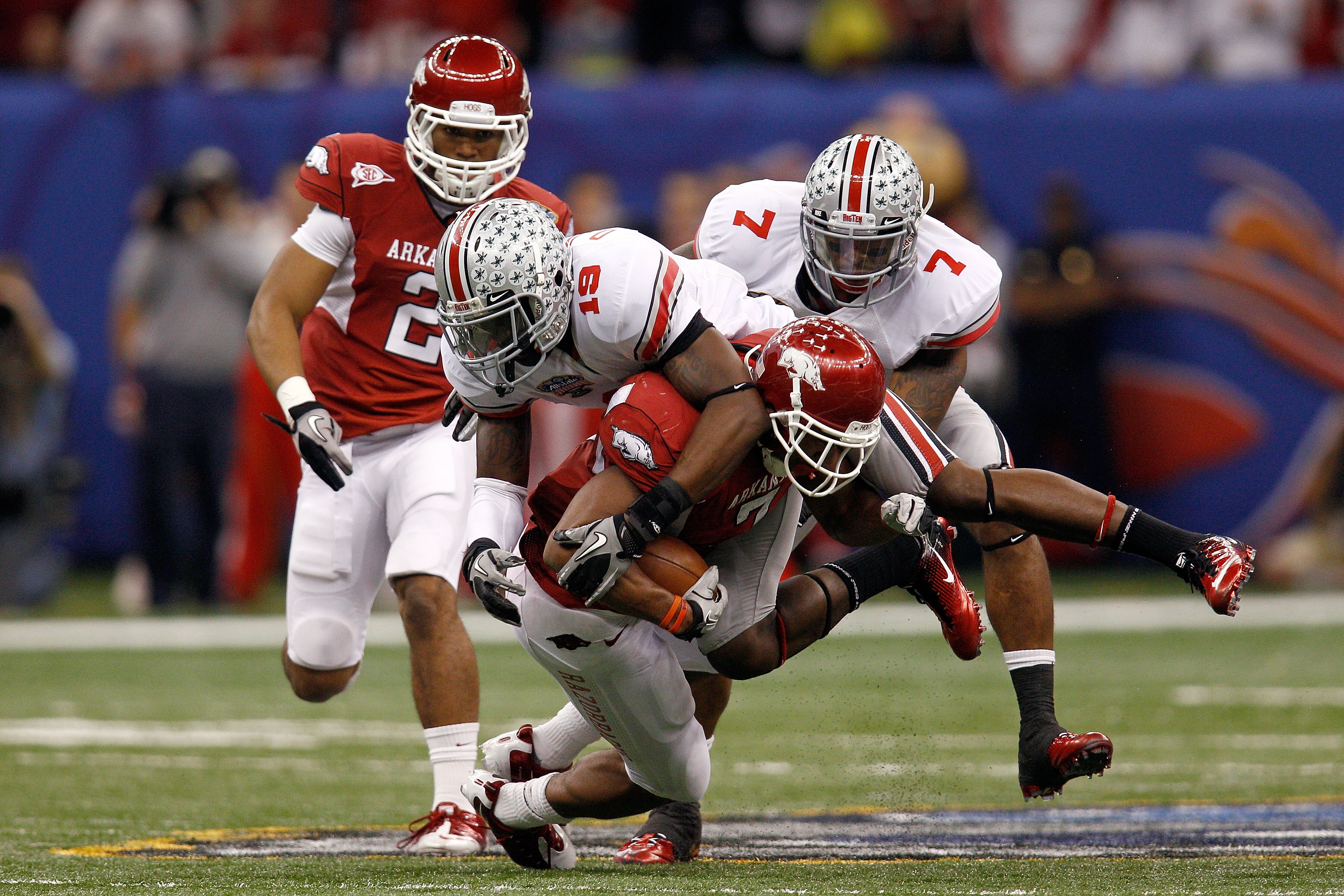 NEW ORLEANS, LA - JANUARY 04:  Knile Davis #7 of the Arkansas Razorbacks runs the ball as Orhian Johnson #19 of the Ohio State Buckeyes attempts to tackle him in the second quarter during the Allstate Sugar Bowl at the Louisiana Superdome on January 4, 20