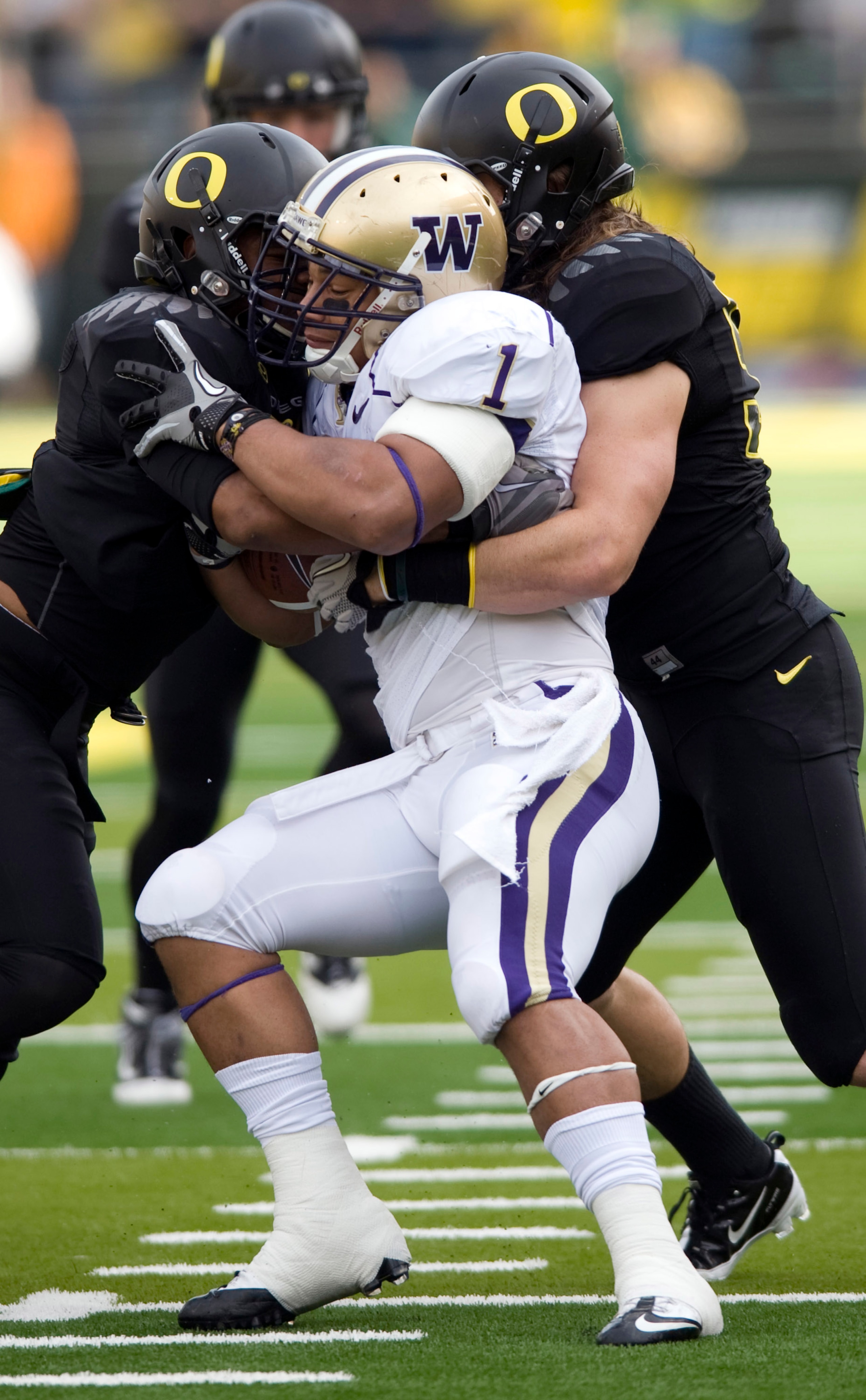 EUGENE, OR - NOVEMBER 6: Linebackers Spencer Paysinger #35 and Casey Matthews #55 of the Oregon Ducks gang up to tackle running back Chris Polk #1 of the Washington Huskies in the first quarter of the game at Autzen Stadium on November 6, 2010 in Eugene, EUGENE, OR - NOVEMBER 6: Linebackers Spencer Paysinger #35 and Casey Matthews #55 of the Oregon Ducks gang up to tackle running back Chris Polk #1 of the Washington Huskies in the first quarter of the game at Autzen Stadium on November 6, 2010 in Eugene,