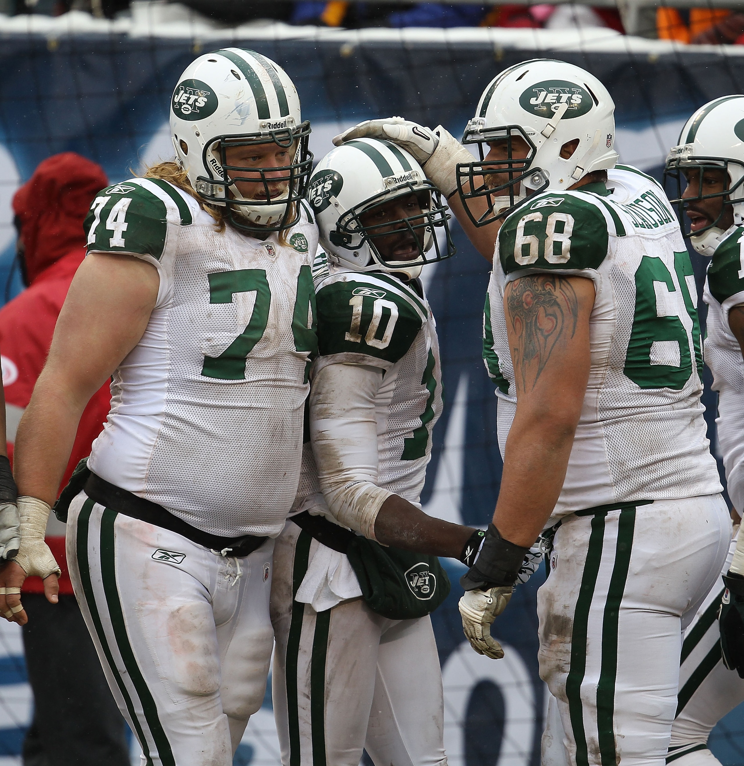 CHICAGO, IL - DECEMBER 26: Santonio Holmes #10 of the New York Jets is congratualted by Nick Mangold #74 and Matt Slauson #68 after scoring a touchdown against the Chicago Bears at Soldier Field on December 26, 2010 in Chicago, Illinois. The Bears defeate