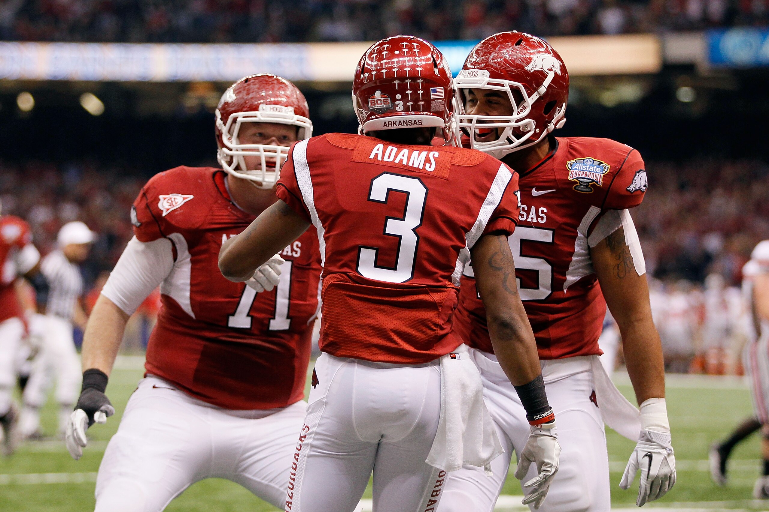 NEW ORLEANS, LA - JANUARY 04:  Joe Adams #3 of the Arkansas Razorbacks reacts with teammates Wade Grayson #71 and D.J. Williams #45 after Adams' catches a 17-yard touchdown pass in the endzone against Travis Howard #18 of the Ohio State Buckeyes in the fi