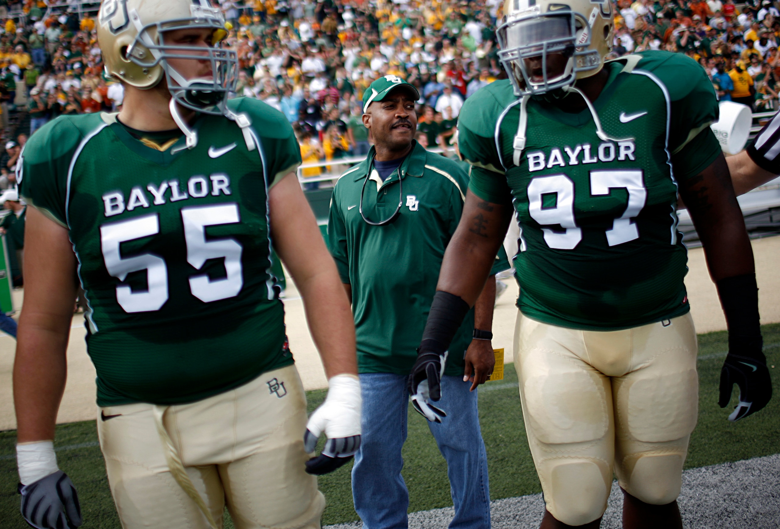 WACO, TX - NOVEMBER 14:  Sgt. Mark Todd of the Fort Hood Police Department walks onto the field with center J.D. Walton #55 and nose tackle Trey Bryant #97 of the Baylor Bears to conduct the coin toss prior to the Texas Longhorns taking on the Baylor Bear