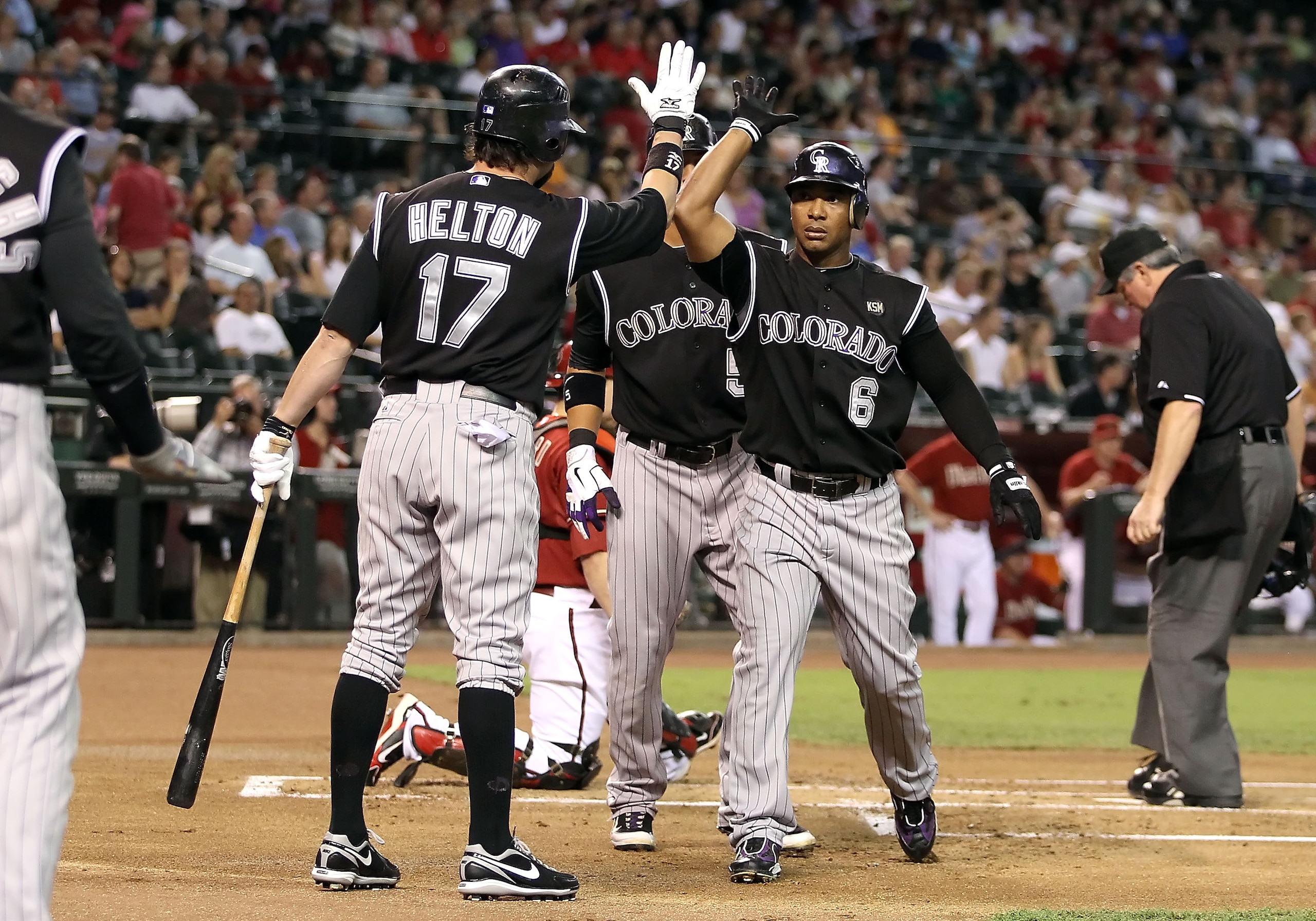 PHOENIX - SEPTEMBER 22:  Melvin Mora #6 of the Colorado Rockies celebrates with Todd Helton #17 after Mora hit a 3 run home run against the Arizona Diamondbacks during the first inning of the Major League Baseball game at Chase Field on September 22, 2010