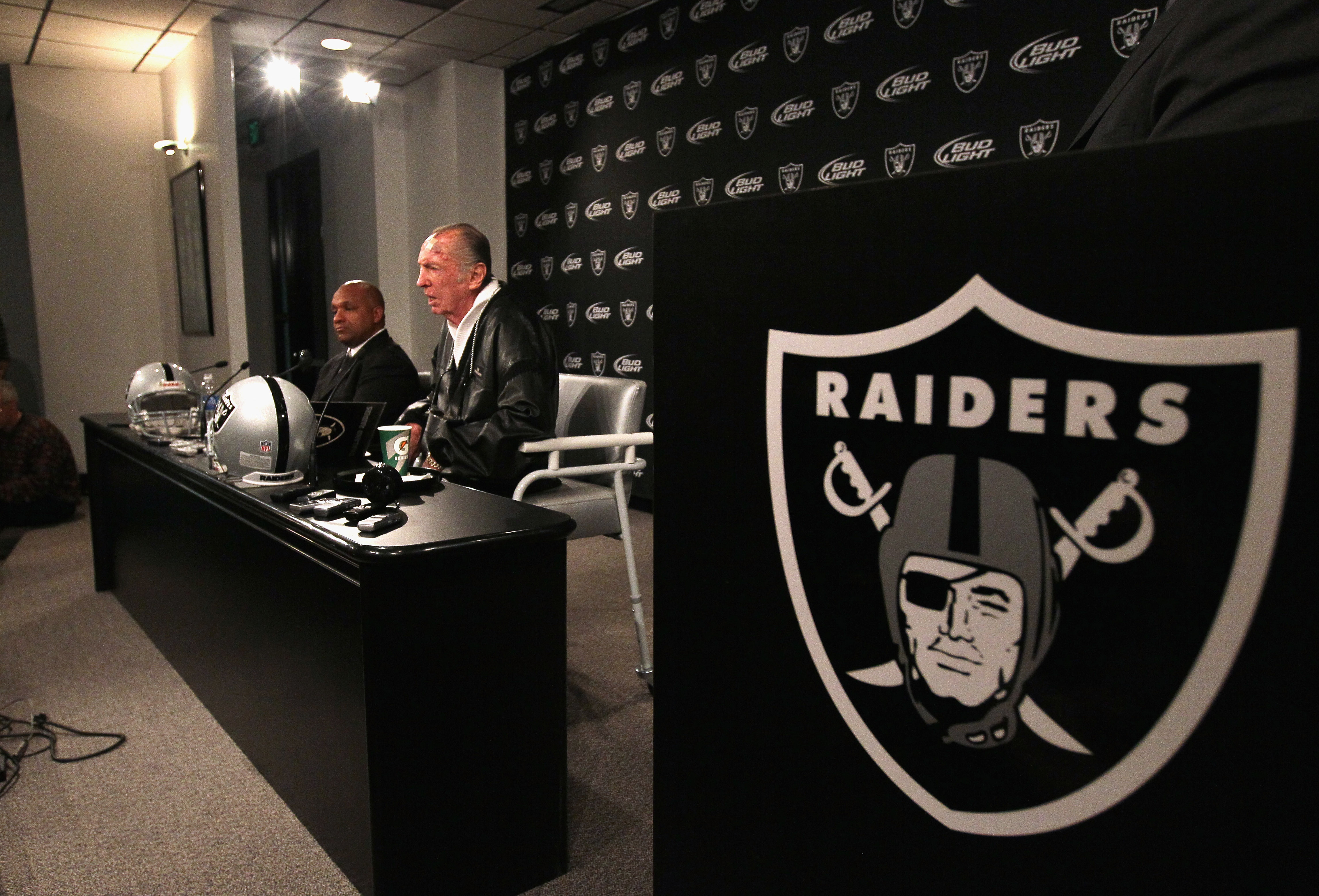 ALAMEDA, CA - JANUARY 18:  New Oakland Raiders coach Hue Jackson (L) looks on as Raiders owner Al Davis speaks during a press conference on January 18, 2011 in Alameda, California. Hue Jackson was introduced as the new coach of the Oakland Raiders, replac