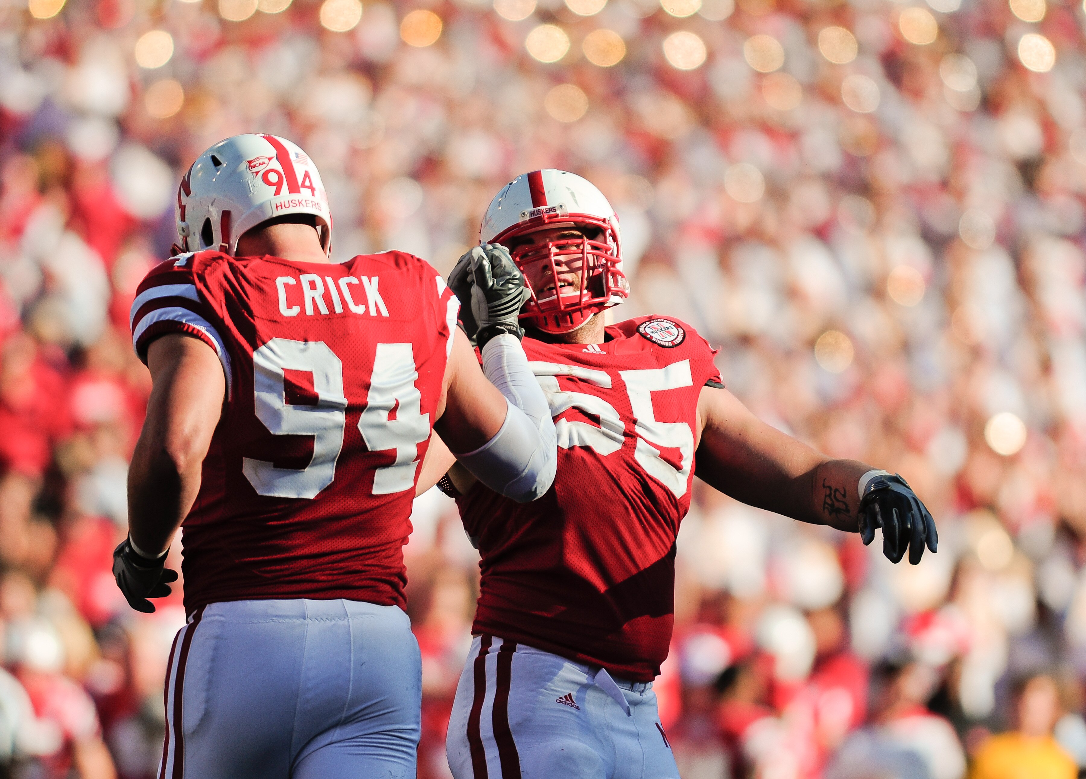 LINCOLN, NE - OCTOBER 30: Defensive tackle Baker Steinkuhler #55  of the Nebraska Cornhuskers high fives teammate  defensive tackle Jared Crick #94 after a third down stop during second half action of their game at Memorial Stadium on October 30, 2010 in