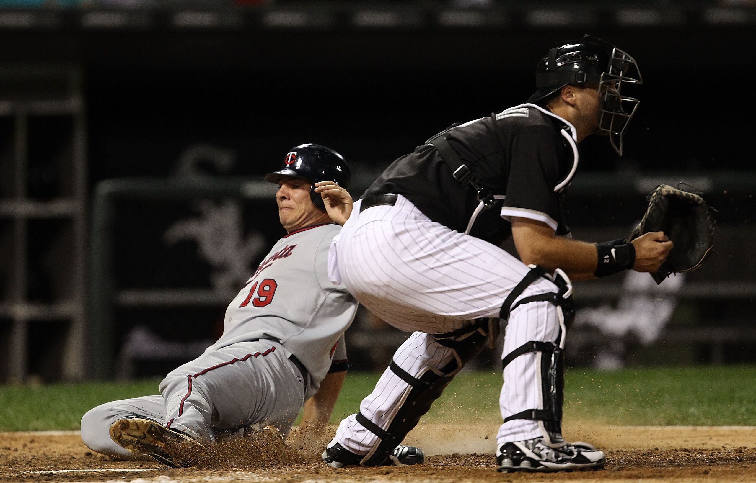 CHICAGO - SEPTEMBER 14: Danny Valencia #19 of the Minnesota Twins scores a run on a double by teammate J.J. Hardy in the 7th inning as A.J. Pierzynski #12 of the Chicago White Sox awaits the throw at U.S. Cellular Field on September 14, 2010 in Chicago, I
