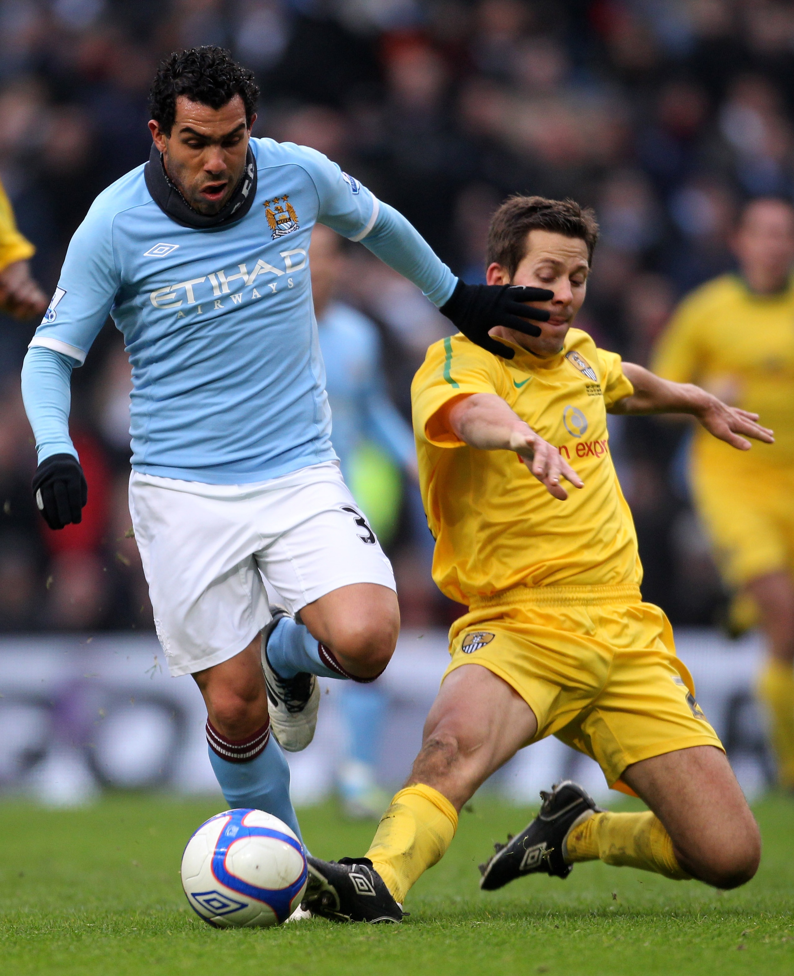 MANCHESTER, ENGLAND - FEBRUARY 20:  Carlos Tevez of Manchester City goes through on goal past Jon Harley of Nott County to score the third goal during the FA Cup sponsored by E.On 4th Round replay match between Manchester City and Notts County at City of 