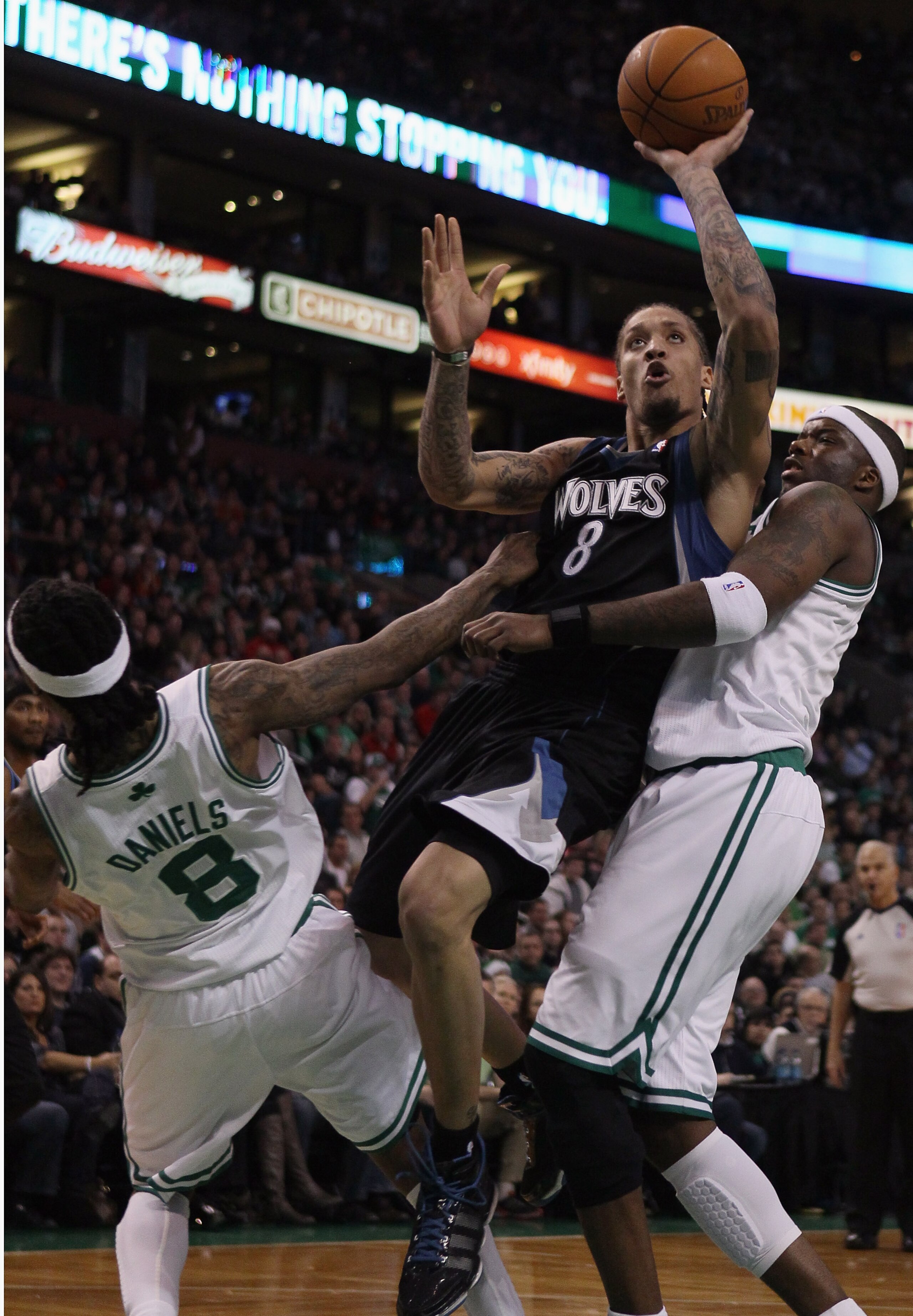 BOSTON, MA - JANUARY 03:  Michael Beasley #8 of the Minnesota Timberwolves is called for an offensive foul as he drives to the net and knocks into Marquis Daniels #8 and Jermaine O'Neal #7 of the Boston Celtics on January 3, 2011 at the TD Garden in Bosto